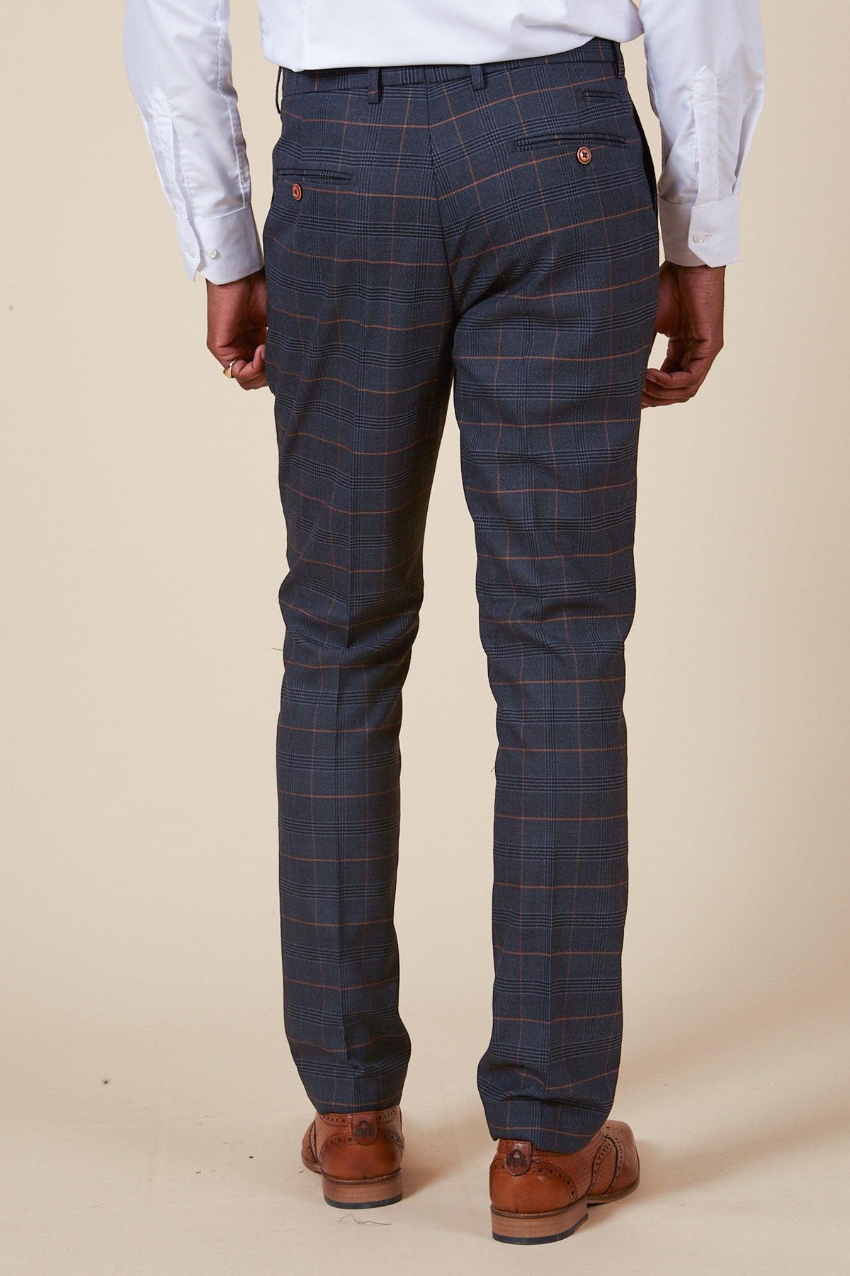 Back view of men's slim-fit JENSON Marine Navy Check Suit trousers from marcdarcy's The Everton Collection, with orange Prince of Wales check, tan buttoned back pockets, styled with a white shirt and tan brogue shoes.