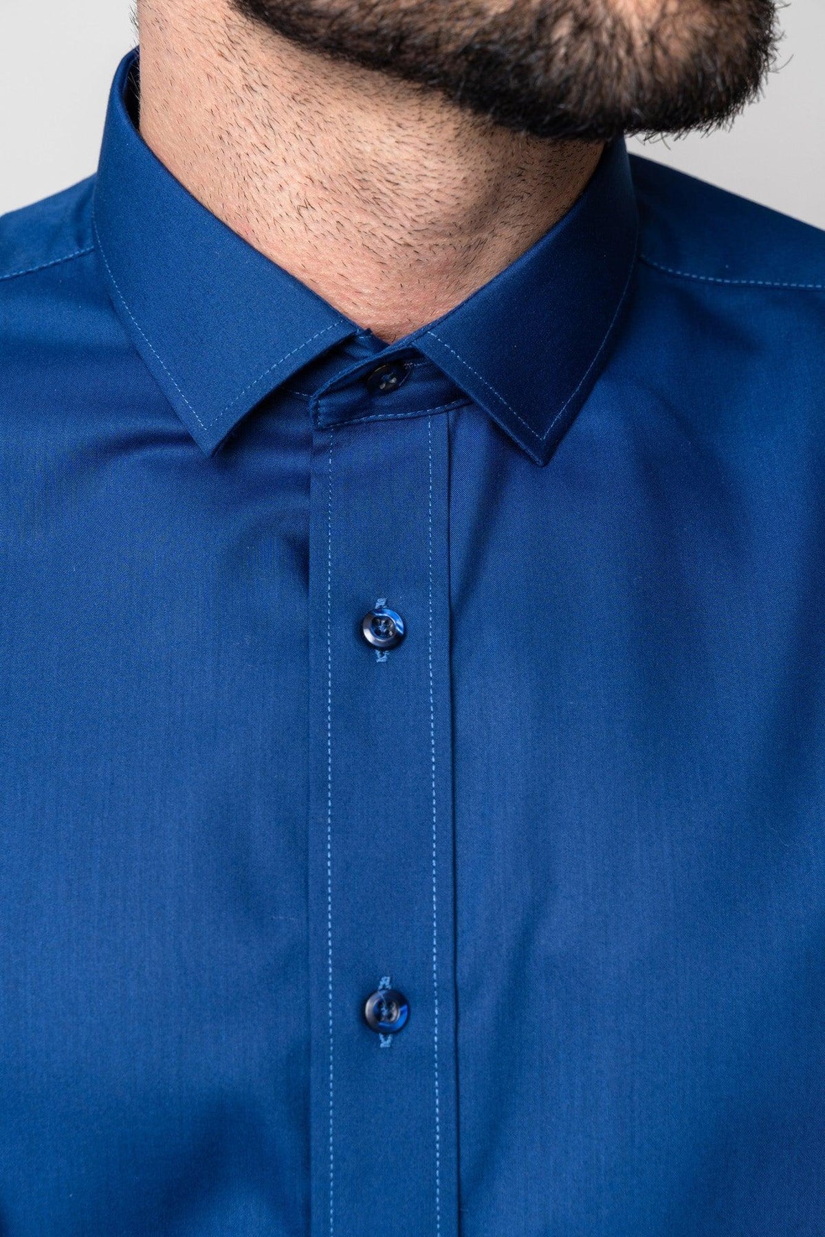 Close-up of a man's lower face and neck, wearing the Marc Darcy CARTER - Navy Long Sleeve Shirt featuring a classic fit, pointed collar, three visible buttons, and fine stitching details.