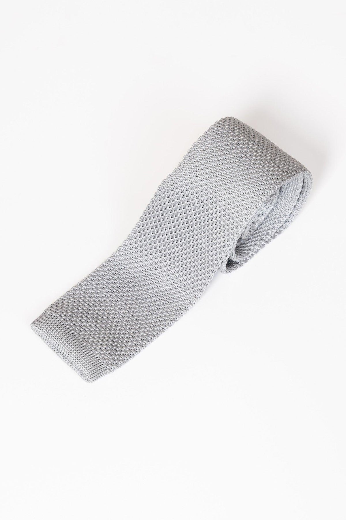 The KT - Silver Grey Knitted Tie by Accessory features a modern textured design, neatly rolled and presented against a white background.