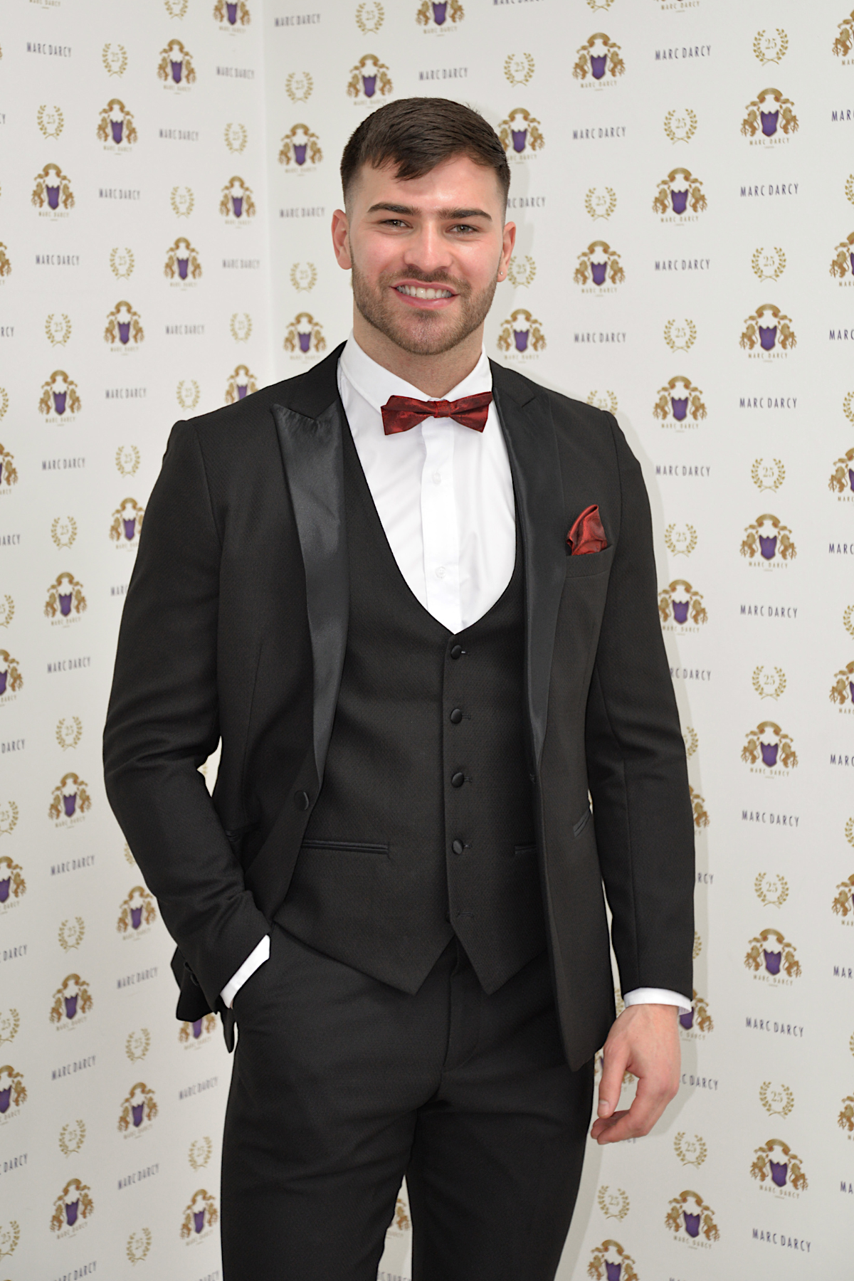 'I’m A Celebrity Get Me Out Of Here' 2022 runner-up Owen Warner smiles in front of a marcdarcy backdrop, wearing the Dalton Black Tuxedo.