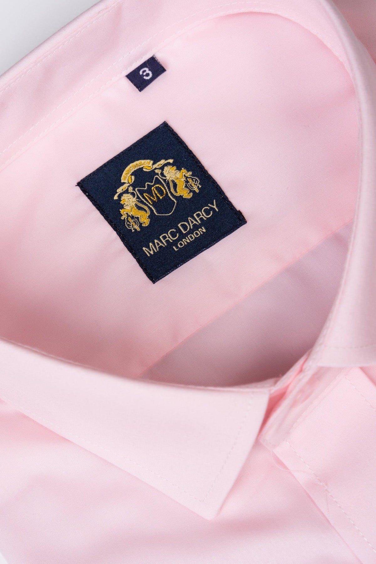 A close-up of the CARTER - Pink Long Sleeve Shirt by Marc Darcy shows its neatly folded design, with a Marc Darcy label inside the collar and a classic spread collar style.