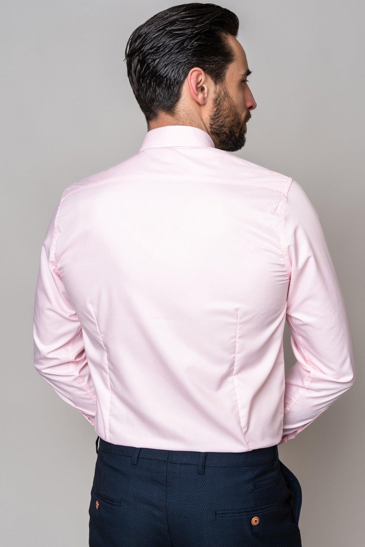 A man faces away from the camera, wearing the Marc Darcy CARTER Pink Long Sleeve Shirt with a spread collar and dark blue patterned dress pants.