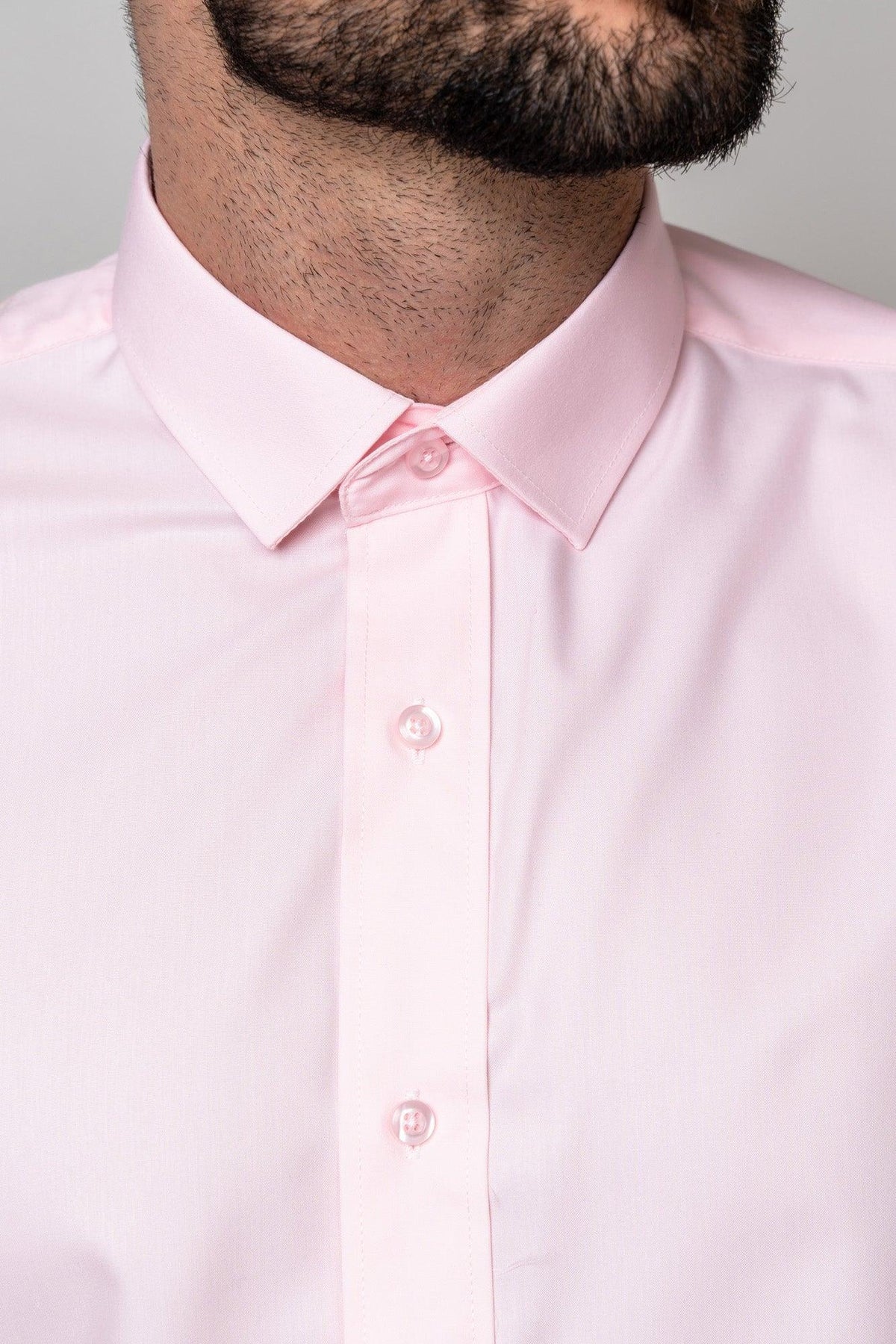 Close-up of a man in the Marc Darcy CARTER Pink Long Sleeve Shirt. Buttoned to the collar, this classic fit piece is perfect for contemporary formalwear, with a hint of his beard visible.
