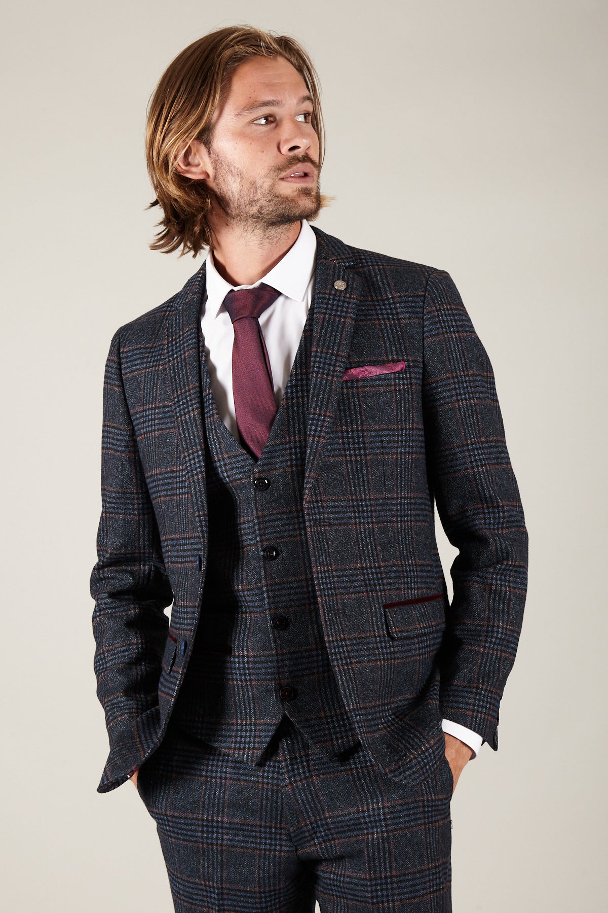 Man wearing the marcdarcy LUCA Navy Check Tweed Blazer with a burgundy tie and pocket square, looking off to the side.
