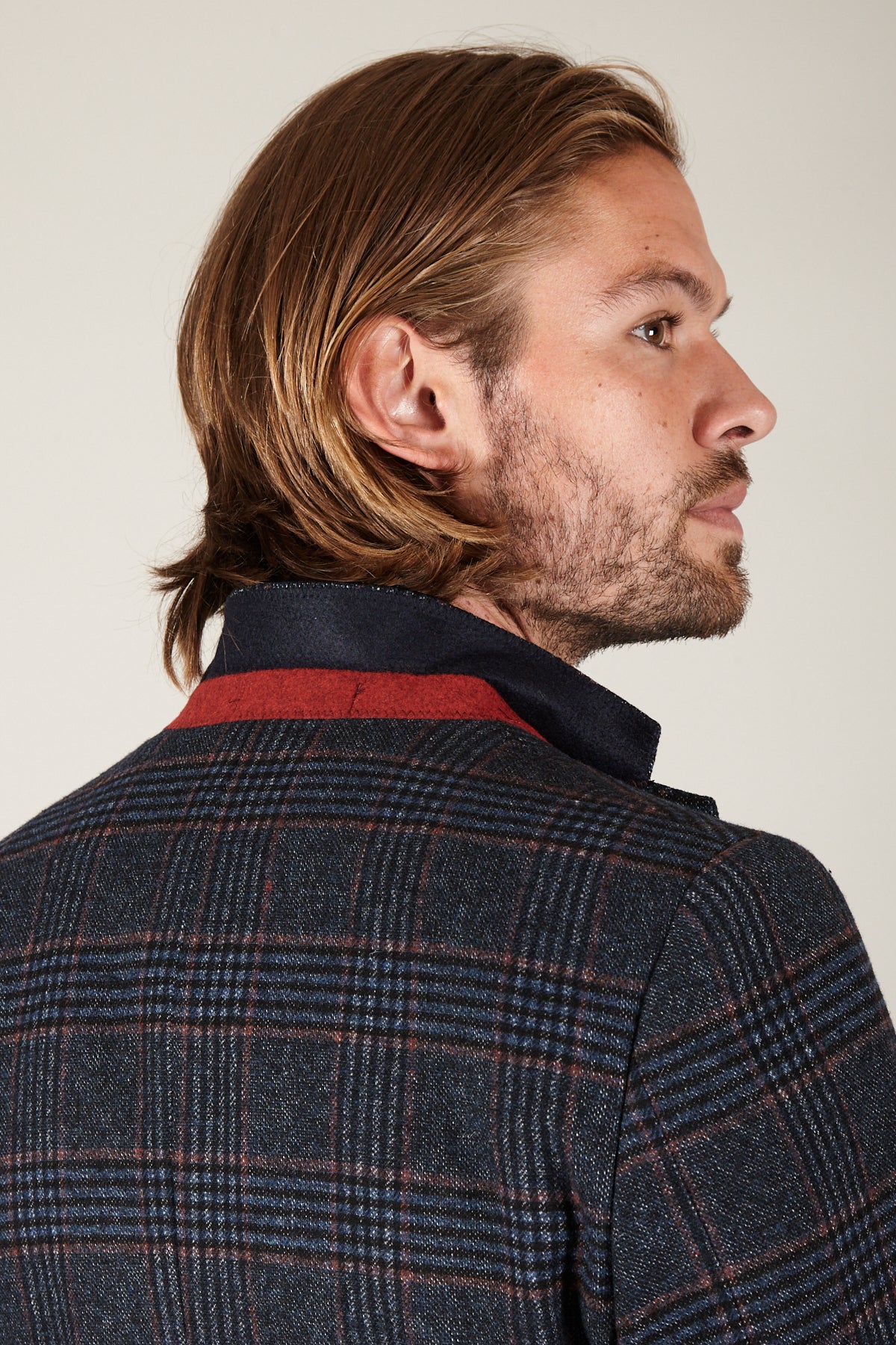 A man with long blonde hair, viewed from the back and side, wearing the marcdarcy LUCA Navy Check Tweed Blazer.