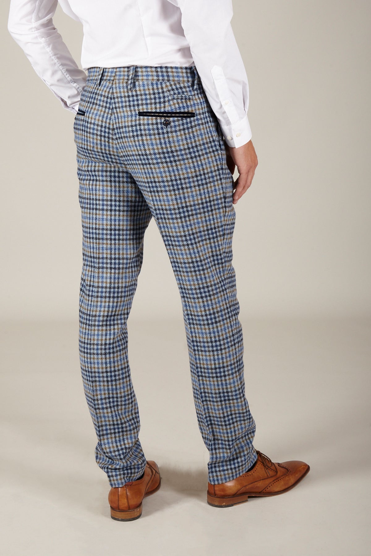 A person stands with their back to the camera on a plain background, wearing marcdarcy WATSON Blue Tan Tweed Check Trousers (slim fit), a white dress shirt, and brown dress shoes.