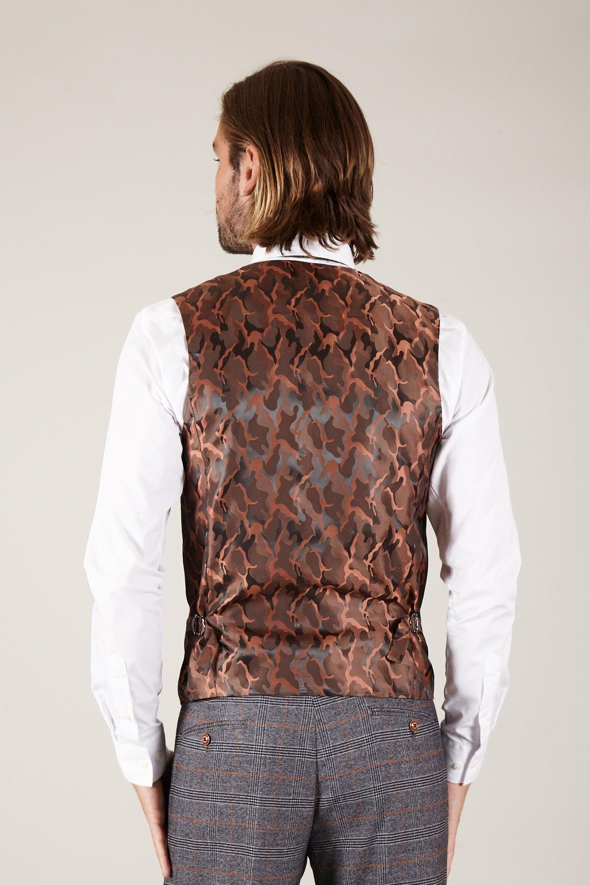 A man with shoulder-length brown hair is seen from the back wearing The Everton Collection: Dominic Calvert-Lewin In The JENSON Grey Suit by marcdarcy, featuring a white dress shirt, brown patterned vest, and grey checked suit trousers.