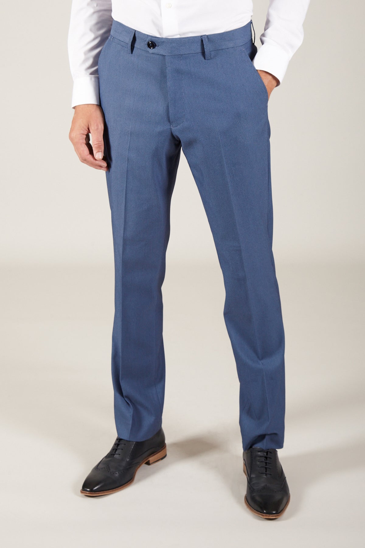 A person models Marc Darcy’s DANNY - Sky Tailored Trousers, featuring a slim fit and lightweight fabric, paired with a white dress shirt and black shoes. The image, cropped at the shoulders, emphasizes the lower body against a plain light background.