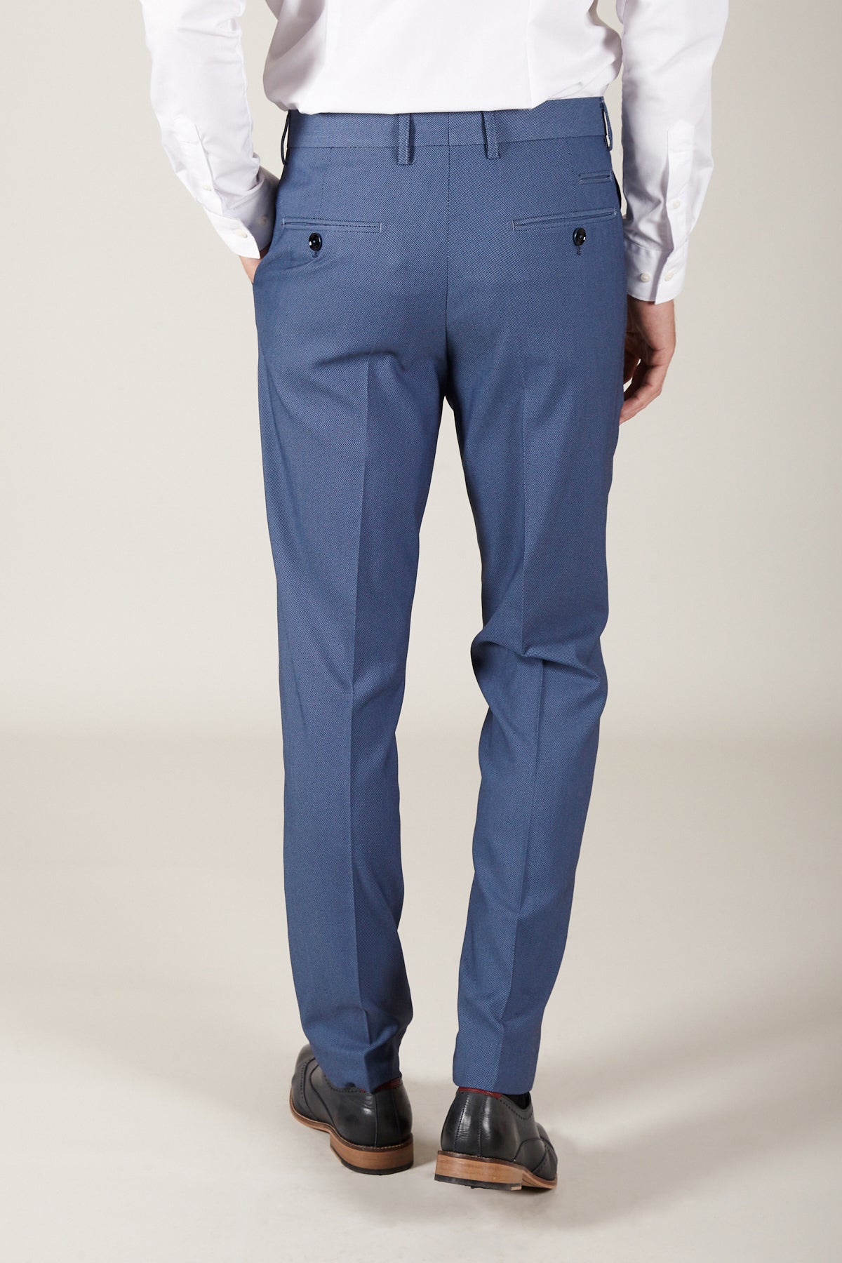 A person wearing a white dress shirt, Marc Darcy DANNY - Sky Tailored Trousers, and black dress shoes stands with their back to the camera against a plain background.