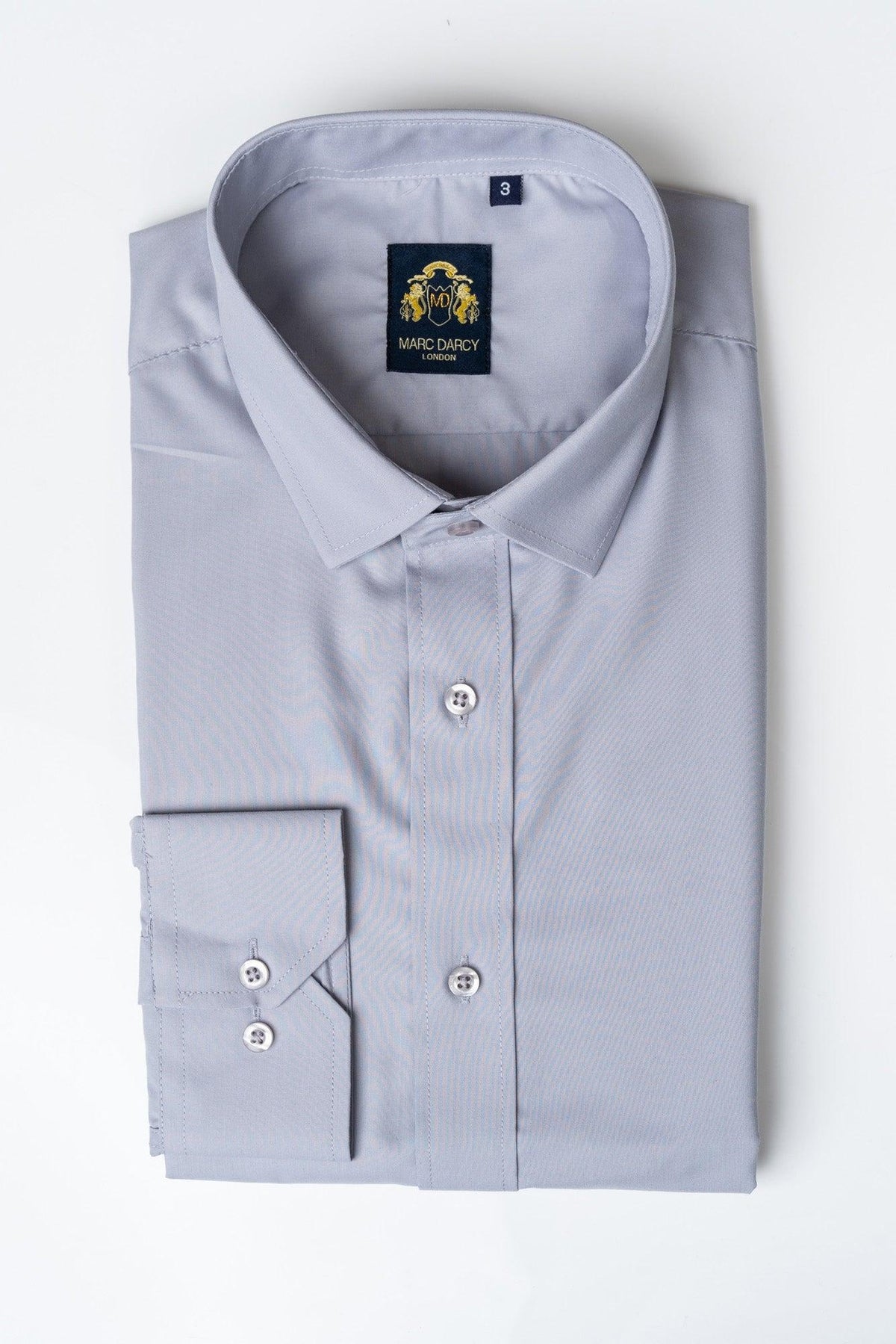 The CARTER - Silver Long Sleeve Shirt by Marc Darcy features a pointed collar and white buttons, neatly folded with the brand label visible inside the collar, displayed on a white background.