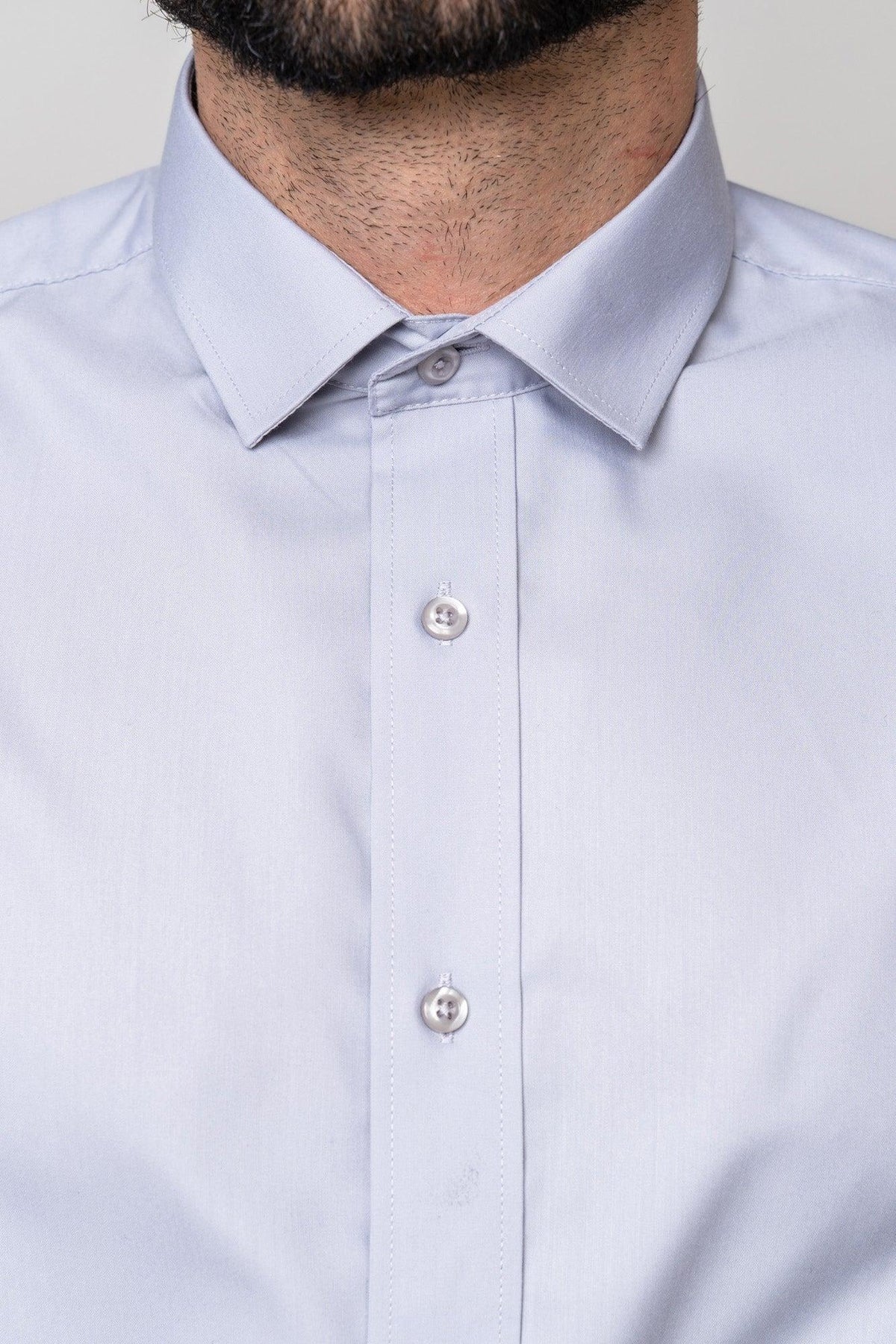 Close-up of a person wearing the Marc Darcy CARTER - Silver Long Sleeve Shirt, featuring a classic collar and three buttons; only the lower half of the face, neck, and upper torso are visible.