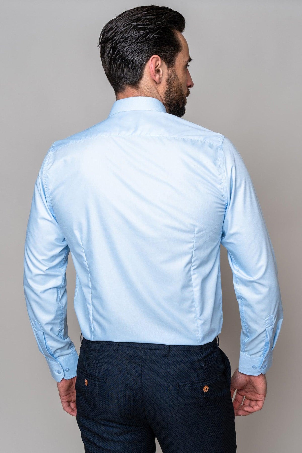 Back view of a man wearing the Marc Darcy CARTER - Sky Long Sleeve Shirt with a spread collar, paired with dark blue patterned pants.