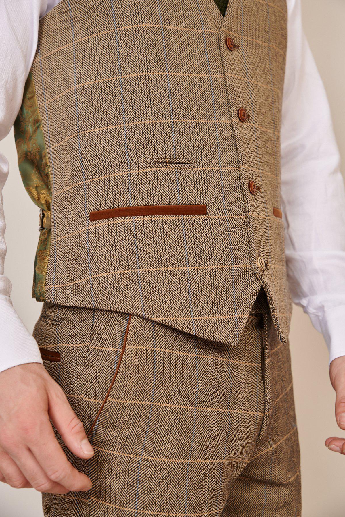 A close-up of Former Manchester City Manager and Footballer Joe Royle in a marcdarcy Max Navy Suit with Ted Waistcoat; only his torso and upper legs are visible.