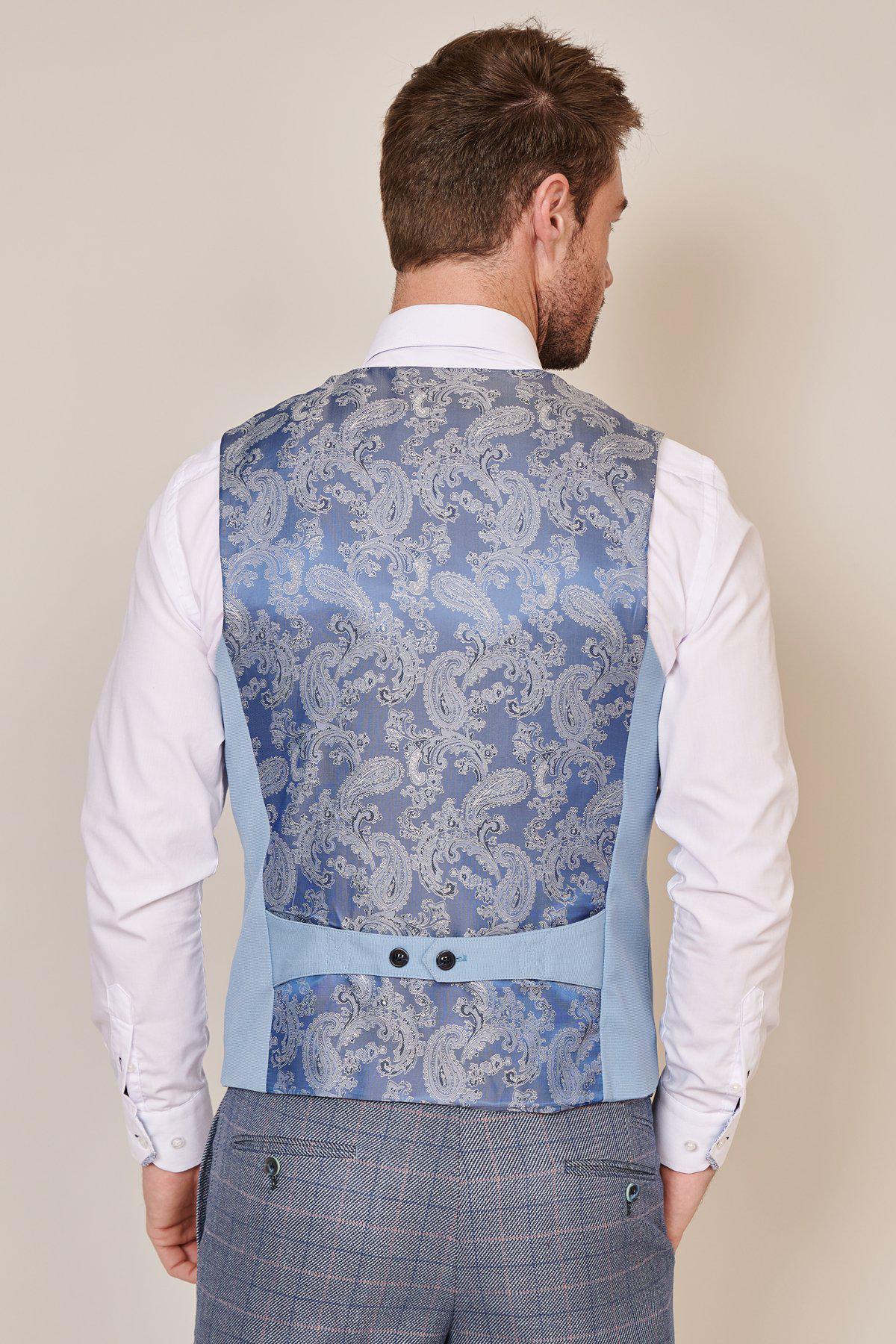 A man wears the marcdarcy KELLY Sky Blue Single Breasted Waistcoat with a blue paisley pattern back, paired with a white shirt and checkered pants.