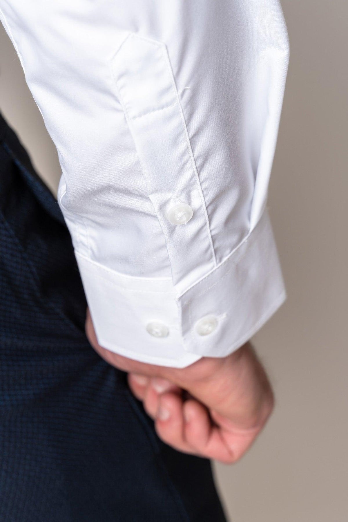 Close-up of a hand in a dark suit pocket, revealing the cuff of the Marc Darcy CARTER White Long Sleeve Shirt—a classic fit men’s staple with visible buttons.