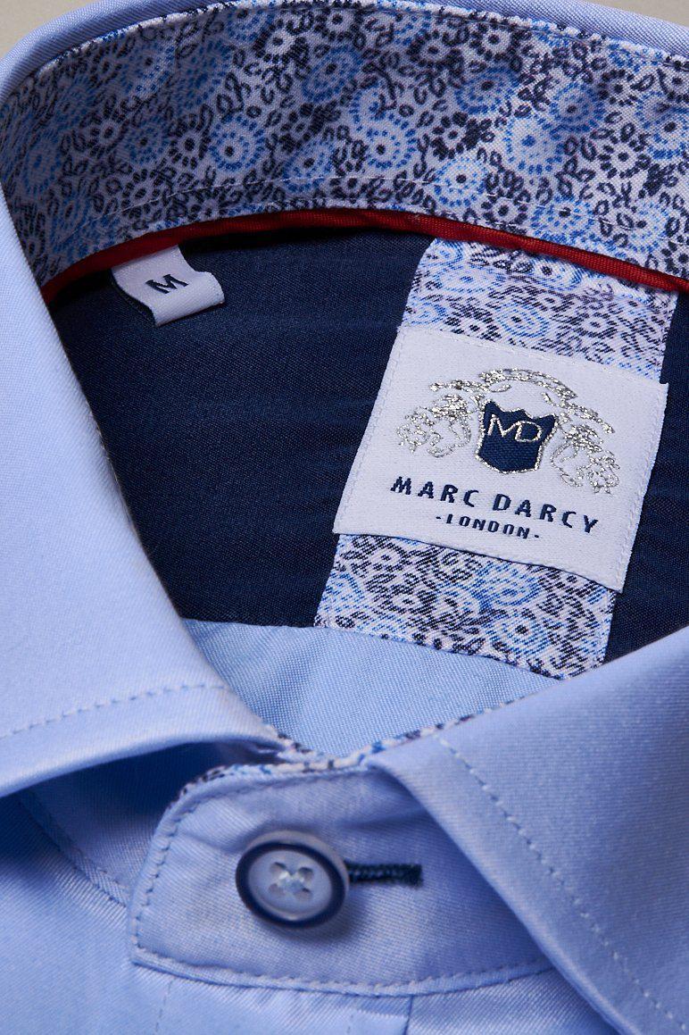 Close-up of the ALFIE - Sky Blue Long Sleeve Shirt by Marc Darcy, featuring a patterned inner collar, subtle floral detail, classic fit, and a visible size M label. The shirt is neatly buttoned at the collar.