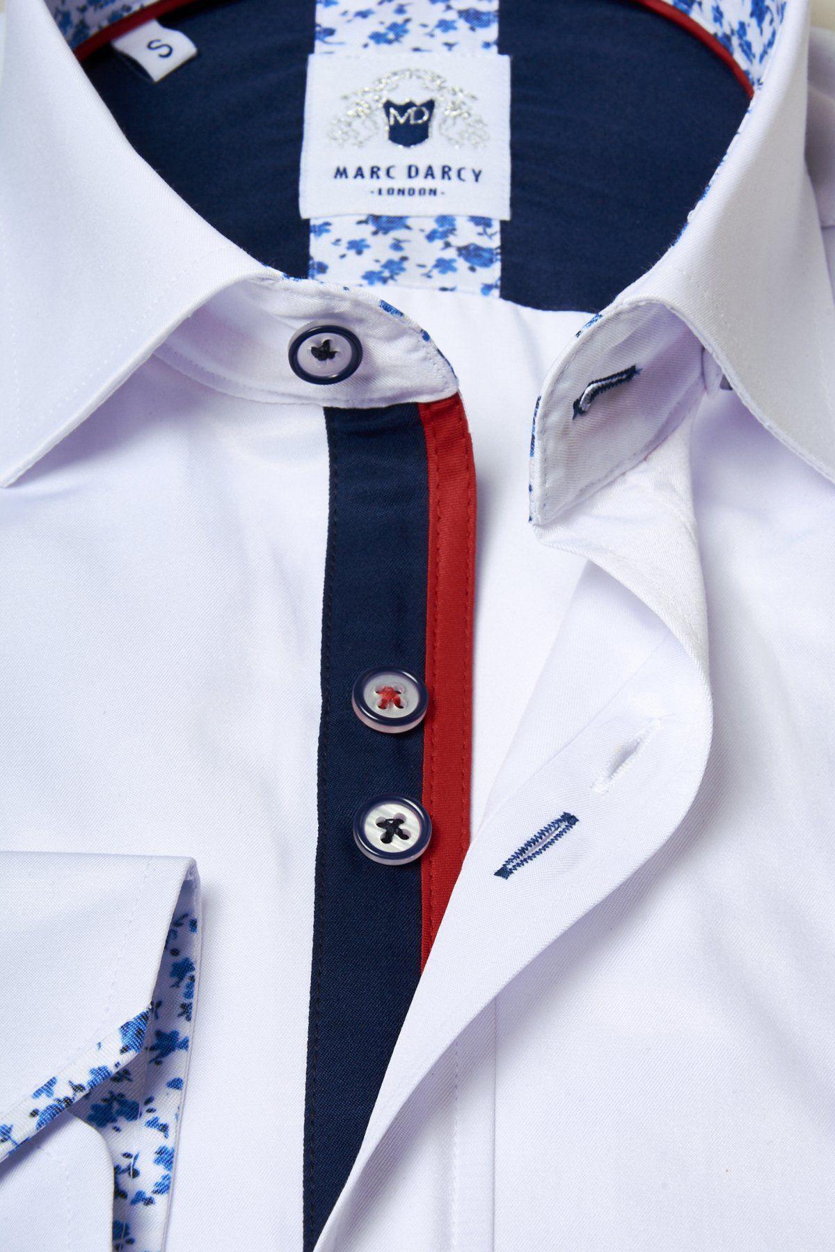 Close-up of the ALFIE white long sleeve shirt by Marc Darcy, featuring a cotton blend, blue and red trim on the button placket, blue floral inner collar and cuffs, navy buttons with red and white accents, and a branded collar label.
