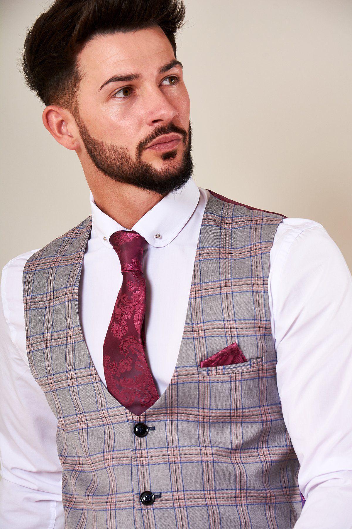 A man with dark hair and a beard wears the Marc Darcy ALVIN Grey Pink Check Single Breasted Waistcoat over a white shirt, paired with a patterned burgundy tie and matching pocket square, looking slightly to the side.