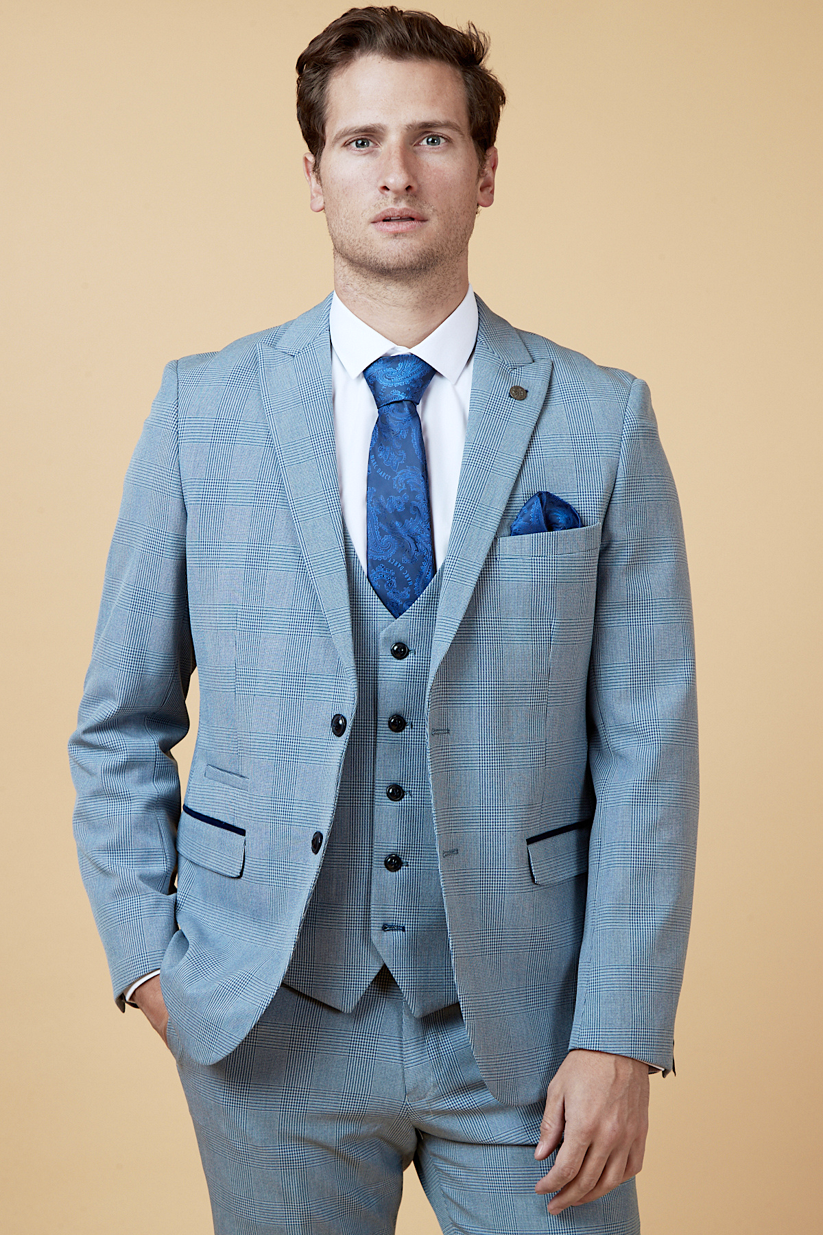 Everton midfielder James Garner wears the marcdarcy Bromley Sky three-piece suit—a light blue slim fit with white shirt, blue paisley tie, and matching pocket square—standing against a tan background.