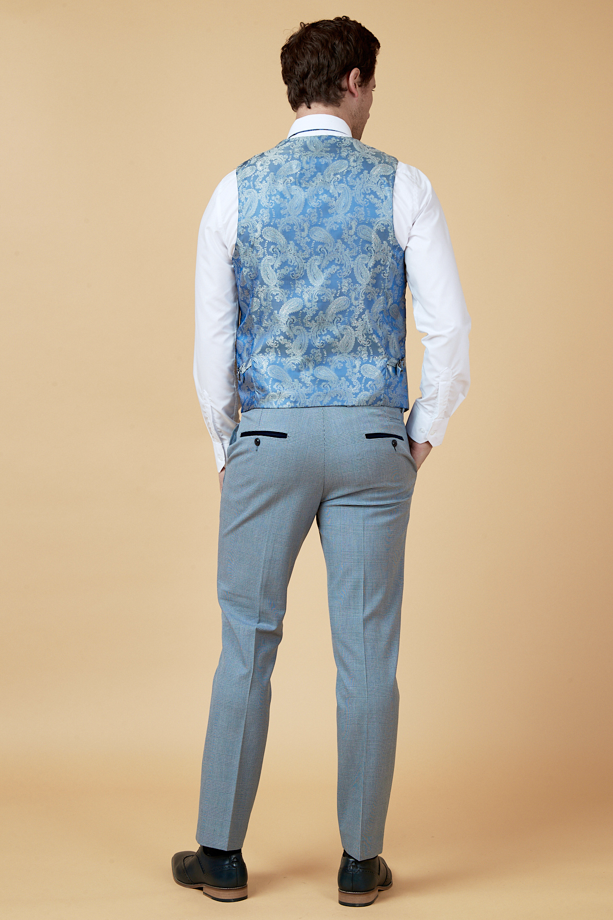 Everton midfielder James Garner wears the marcdarcy Bromley Sky Three Piece Suit, featuring a white shirt, light blue patterned vest, and light gray slim fit pants with black shoes against a plain beige background.