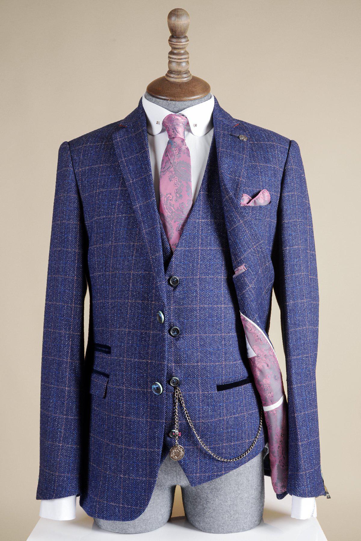 A mannequin displays a blue checkered three-piece suit with a pink paisley tie and pocket square, finished with a Marc Darcy Antique Style Silver Plated T-Bar Waistcoat Chain. The suit’s inner lining also features a pink paisley pattern.