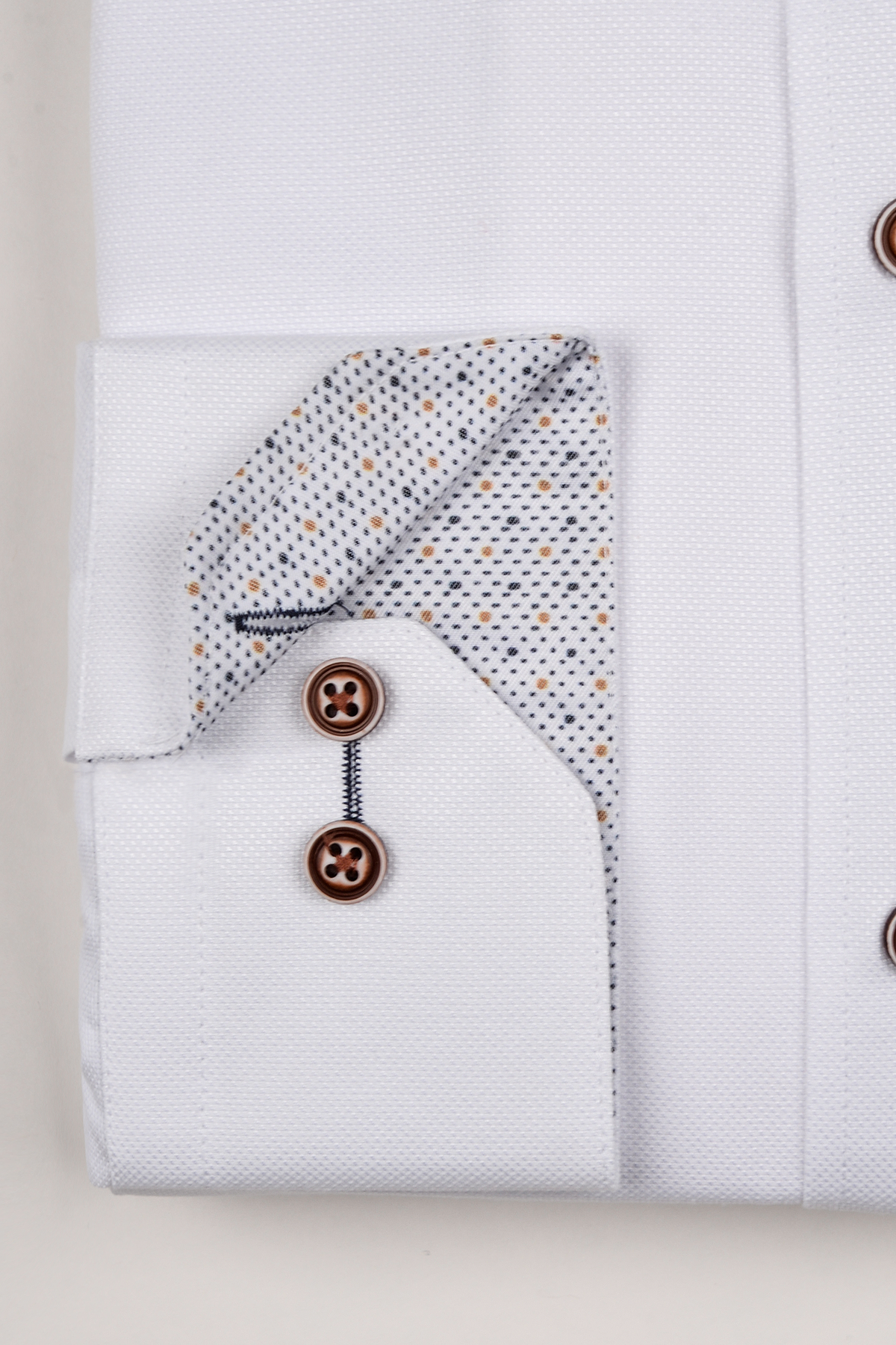 The ARCHIE by Marc Darcy is a white grandad collar shirt featuring tan buttons and a patterned cuff lining.