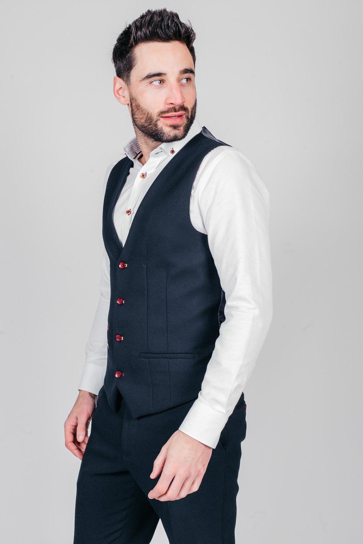 Newcastle United and England goalkeeper Nick Pope wears a marcdarcy JD4 Navy Suit, featuring a dark blue vest and matching trousers, over a white shirt. He stands against a plain light gray background, looking to his left.