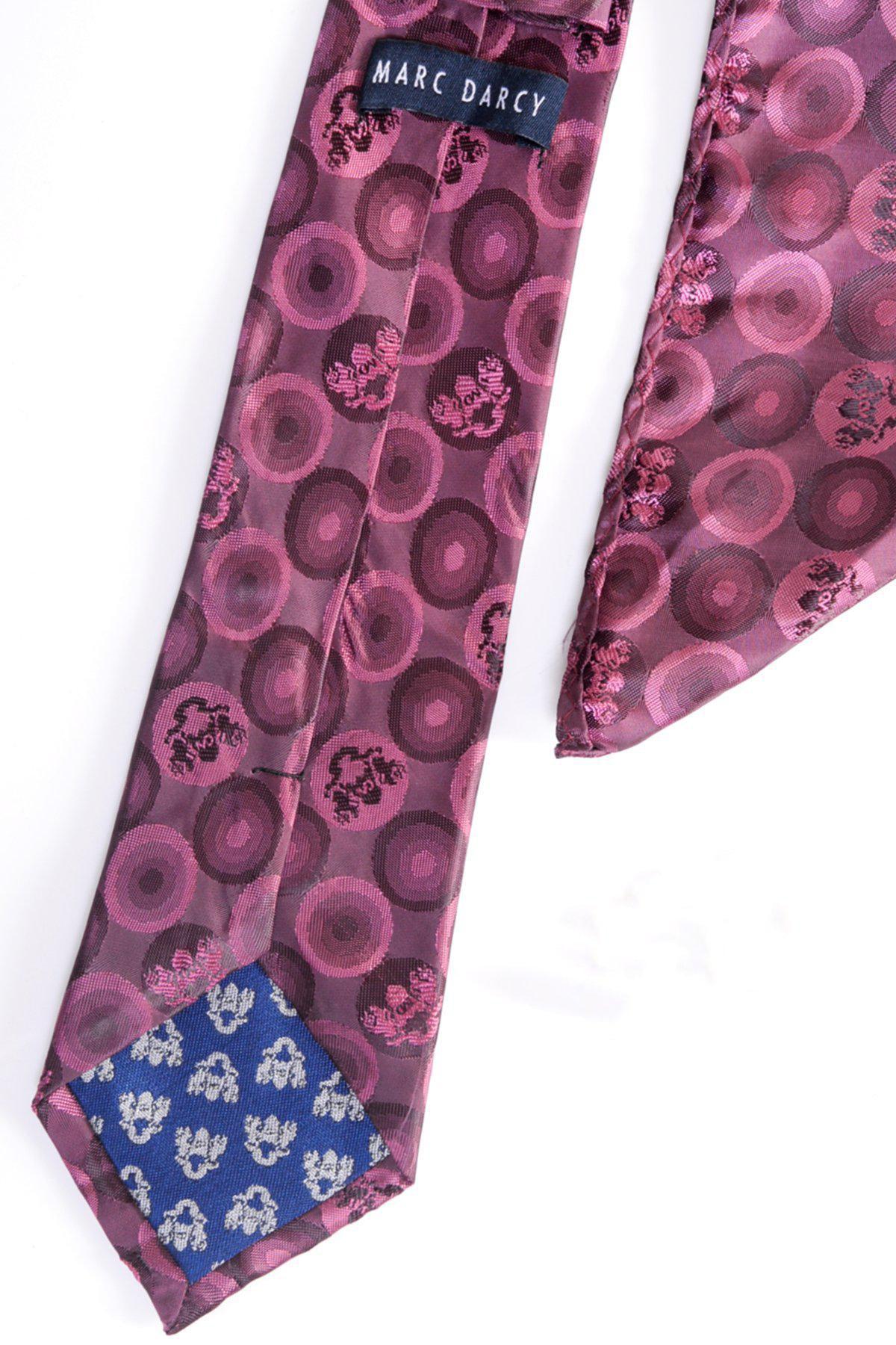 A detailed look at the Marc Darcy BUBBLES - Berry Bubble Circle Print Tie and Pocket Square Set, featuring a berry tone with pink and purple circles, blue floral tip, and signature label on the underside.
