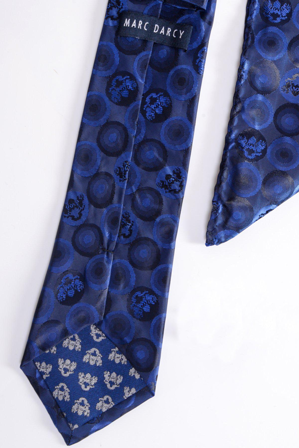 A close-up of the BUBBLES - Navy Bubble Circle Print Tie and Pocket Square Set by Marc Darcy, featuring circular and floral patterns, with the brand label visible on the back. The formal set is displayed flat on a white surface.