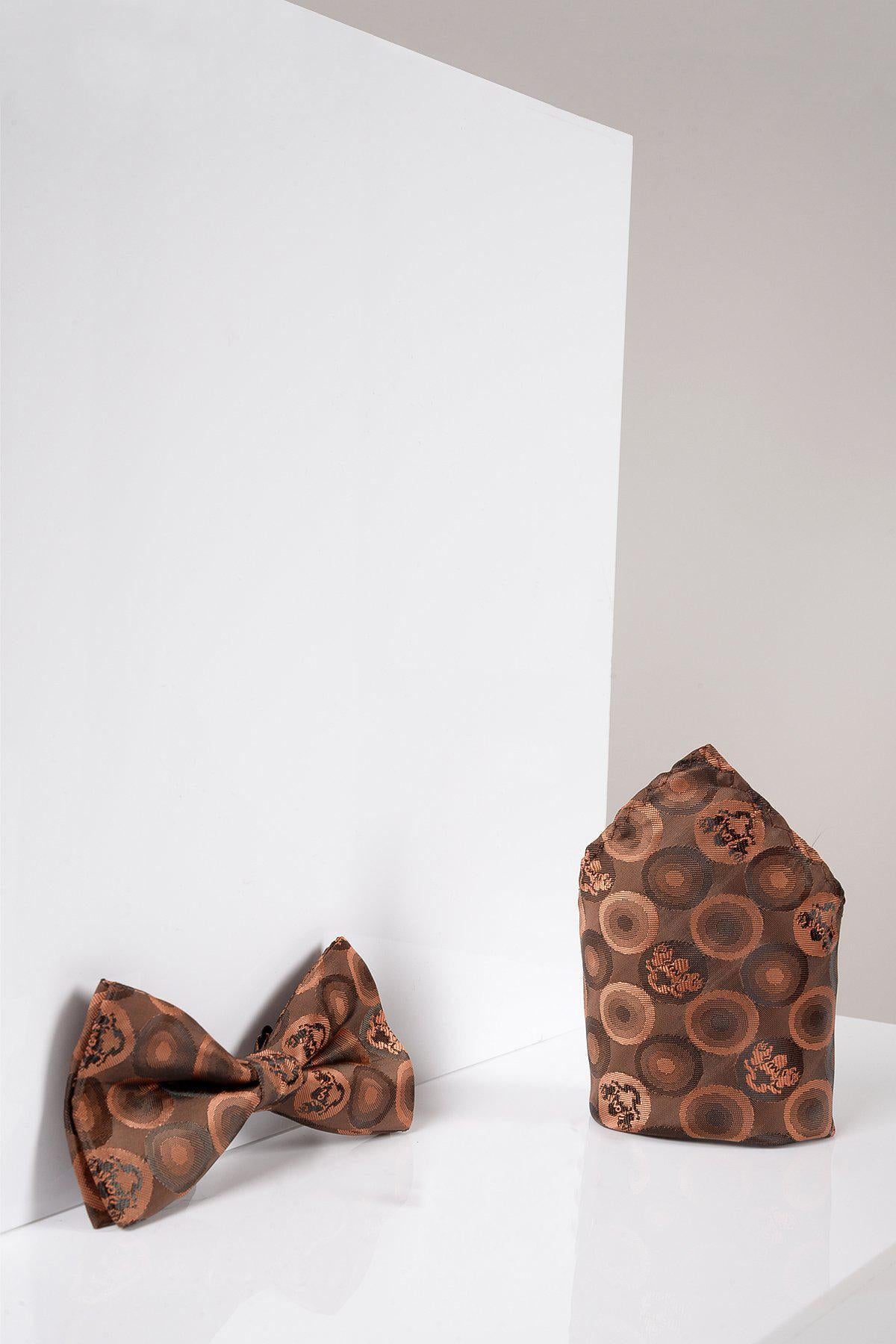 The Marc Darcy BUBBLES Orange Brown Bubble Circle Print Bow Tie and Pocket Square Set is displayed upright on a glossy white surface against a white geometric background.