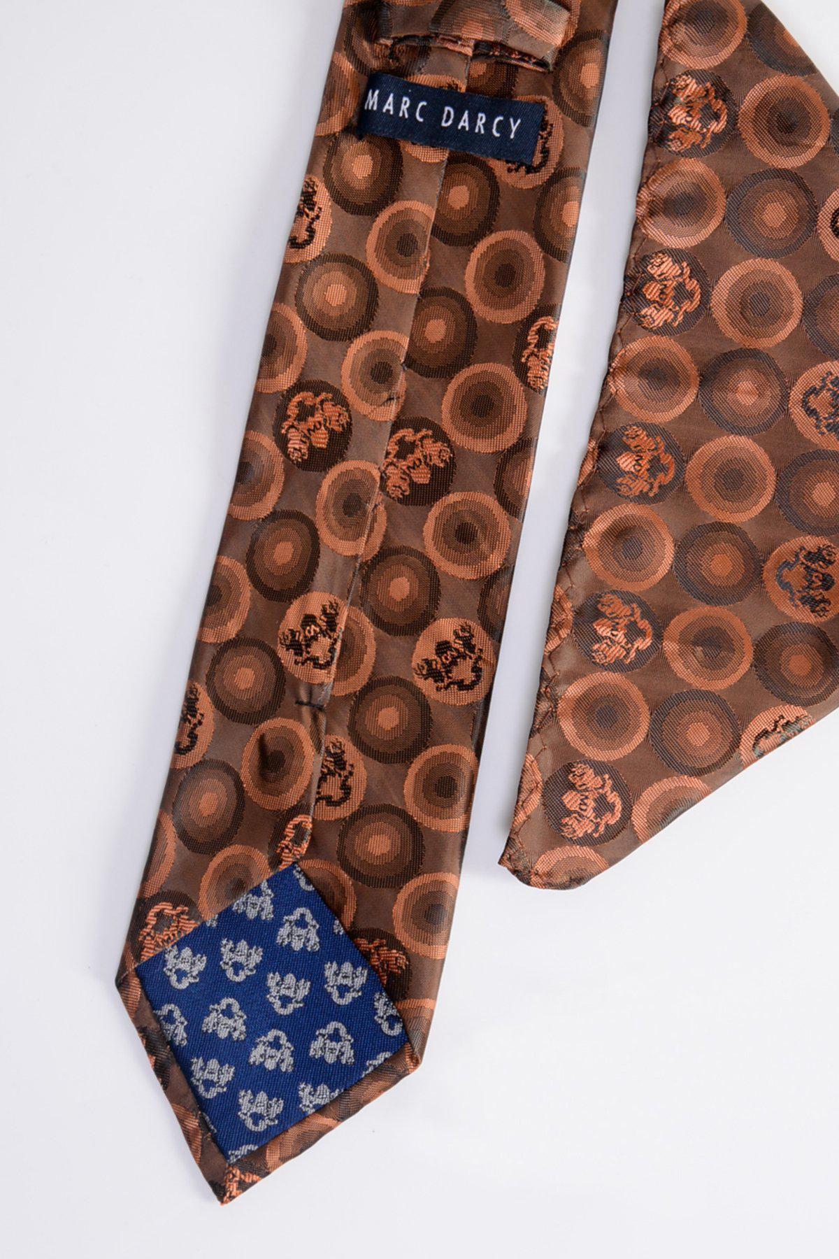 A close-up of the Marc Darcy BUBBLES Orange Brown Bubble Circle Print Tie, featuring the label and a blue inner tip with small white floral motifs.