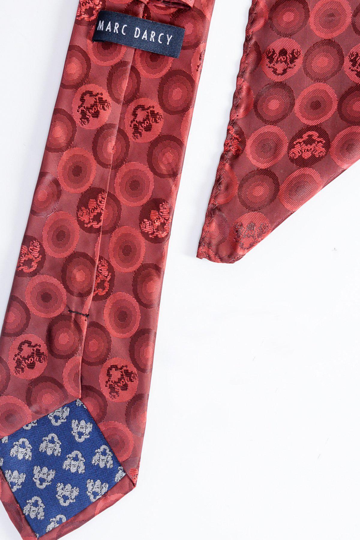 The BUBBLES - Wine Bubble Circle Print Tie and Pocket Square Set by Marc Darcy features circular designs and a blue floral tip. Perfect for formalwear, the tie’s label is sewn on the back and photographed on a white surface.