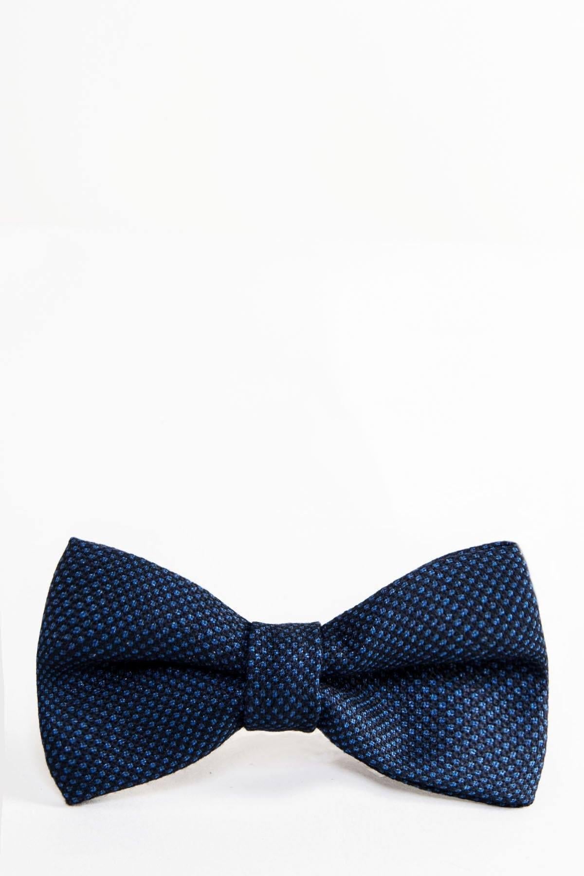 The CALLUM - Navy Blue Birdseye Bow Tie by Accessory features a textured, subtle checkered pattern from birdseye weave and is shown against a plain white background.