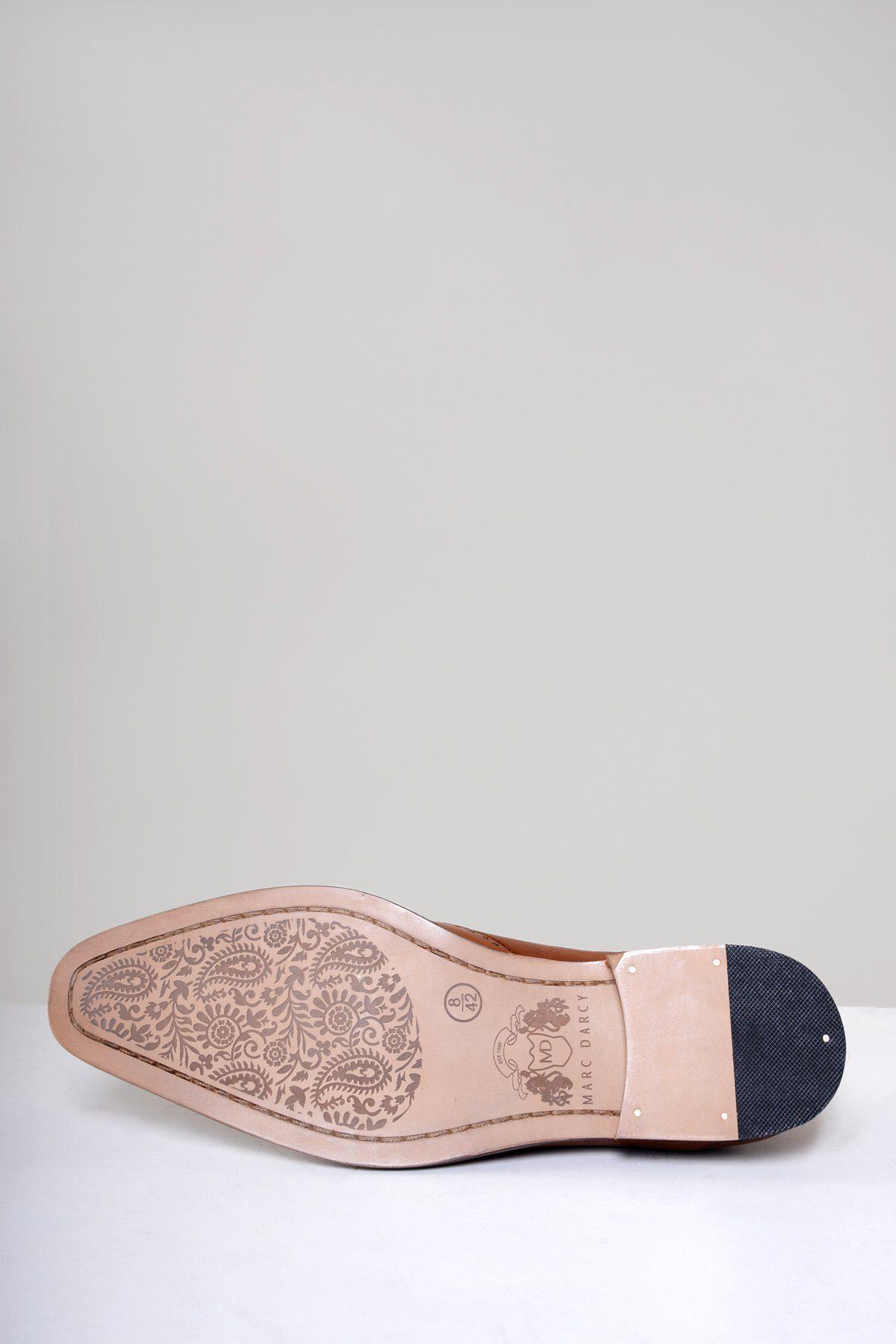The image displays the sole of the Marc Darcy CARSON Mid Tan Wingtip Oxford Brogue Shoe, crafted from full grain leather with an etched floral design, a small logo, a black textured reinforced heel, and two metal studs.