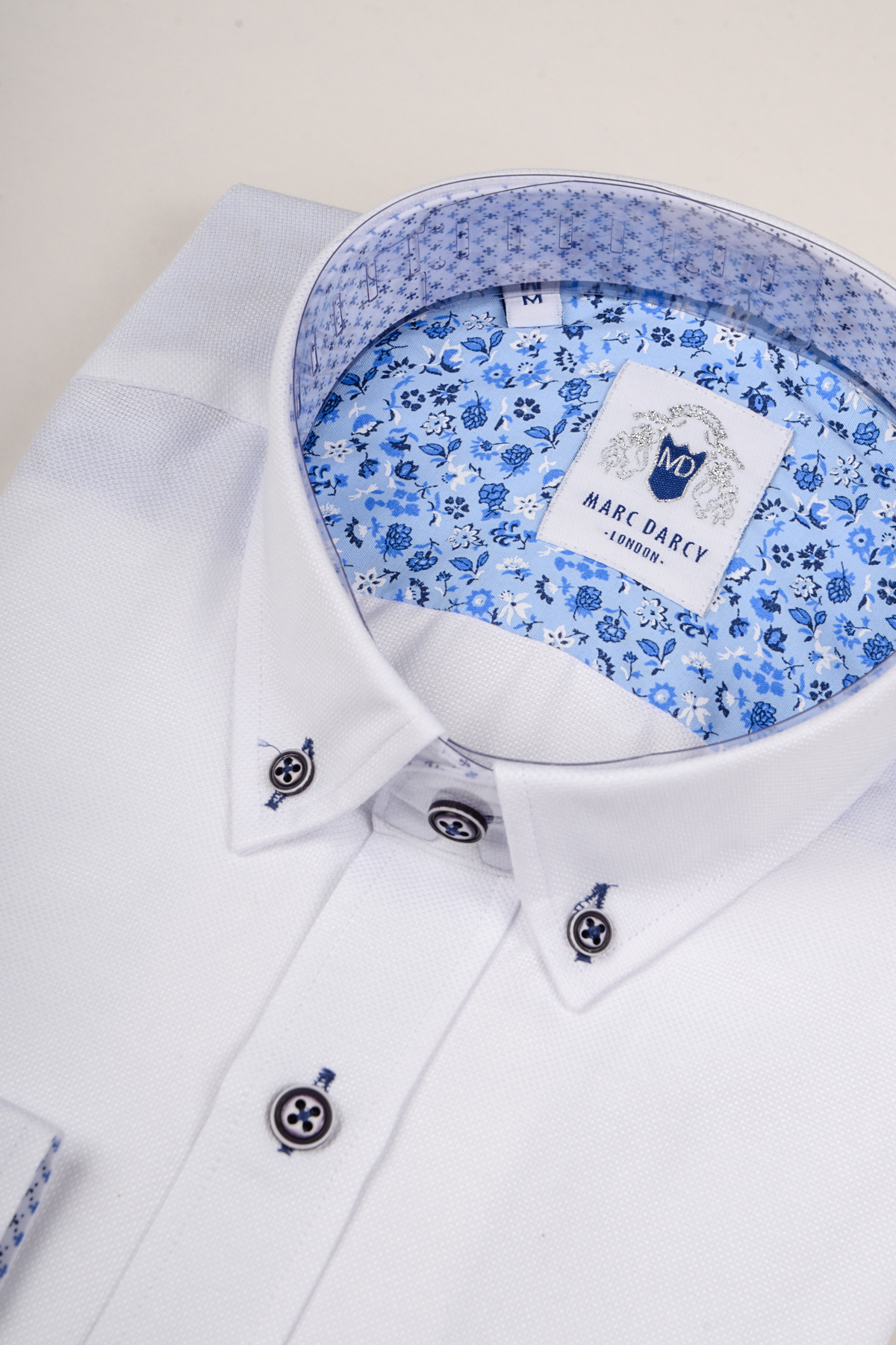 The Marc Darcy CHARLIE White Oxford Shirt features blue buttons and a blue floral inner collar lining, offering a smart-casual look perfect for any occasion.