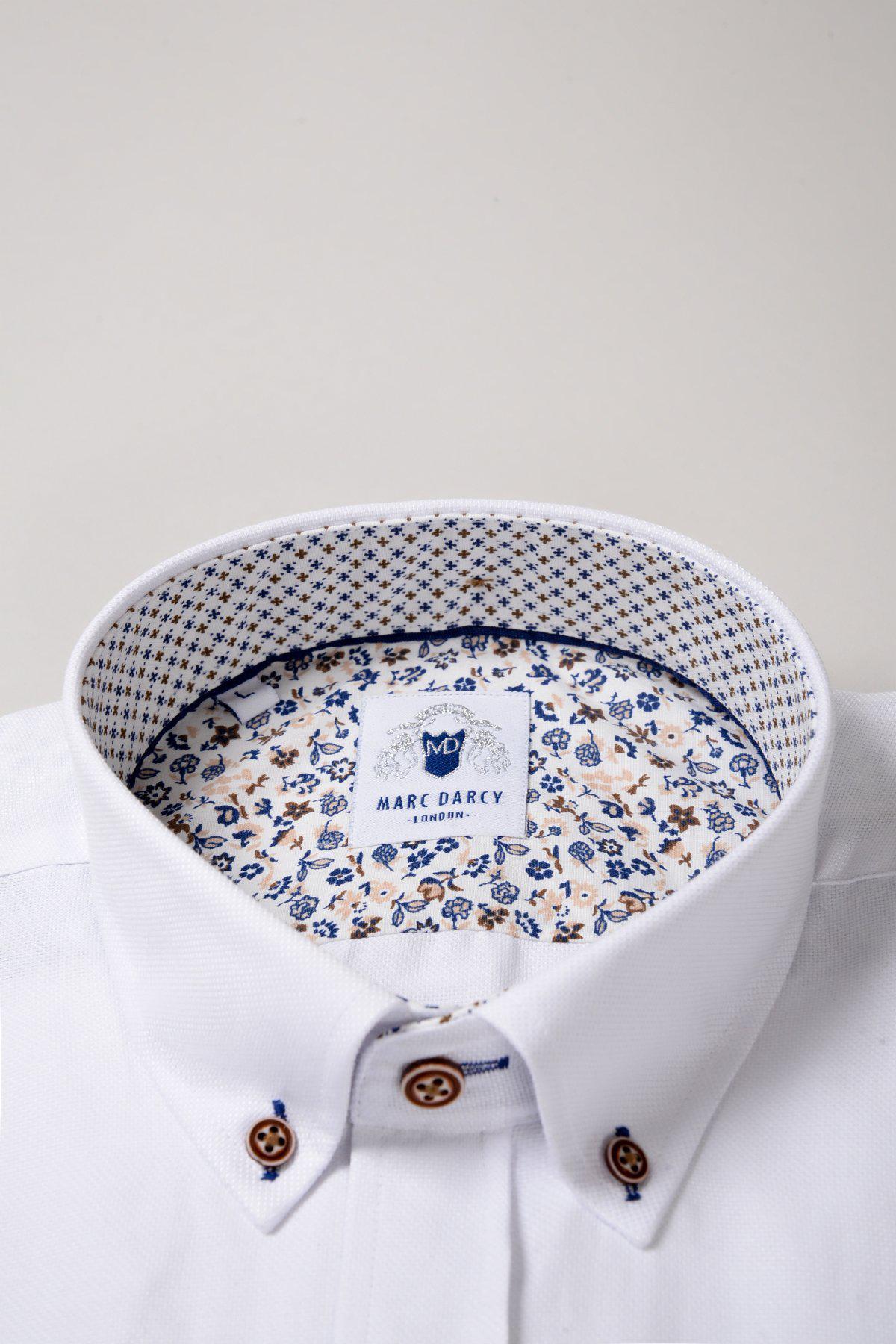 The CHARLIE White Oxford Shirt by Marc Darcy features tan contrast buttons and a subtle floral pattern inside the collar and placket, crafted from a cotton blend for a smart casual look.