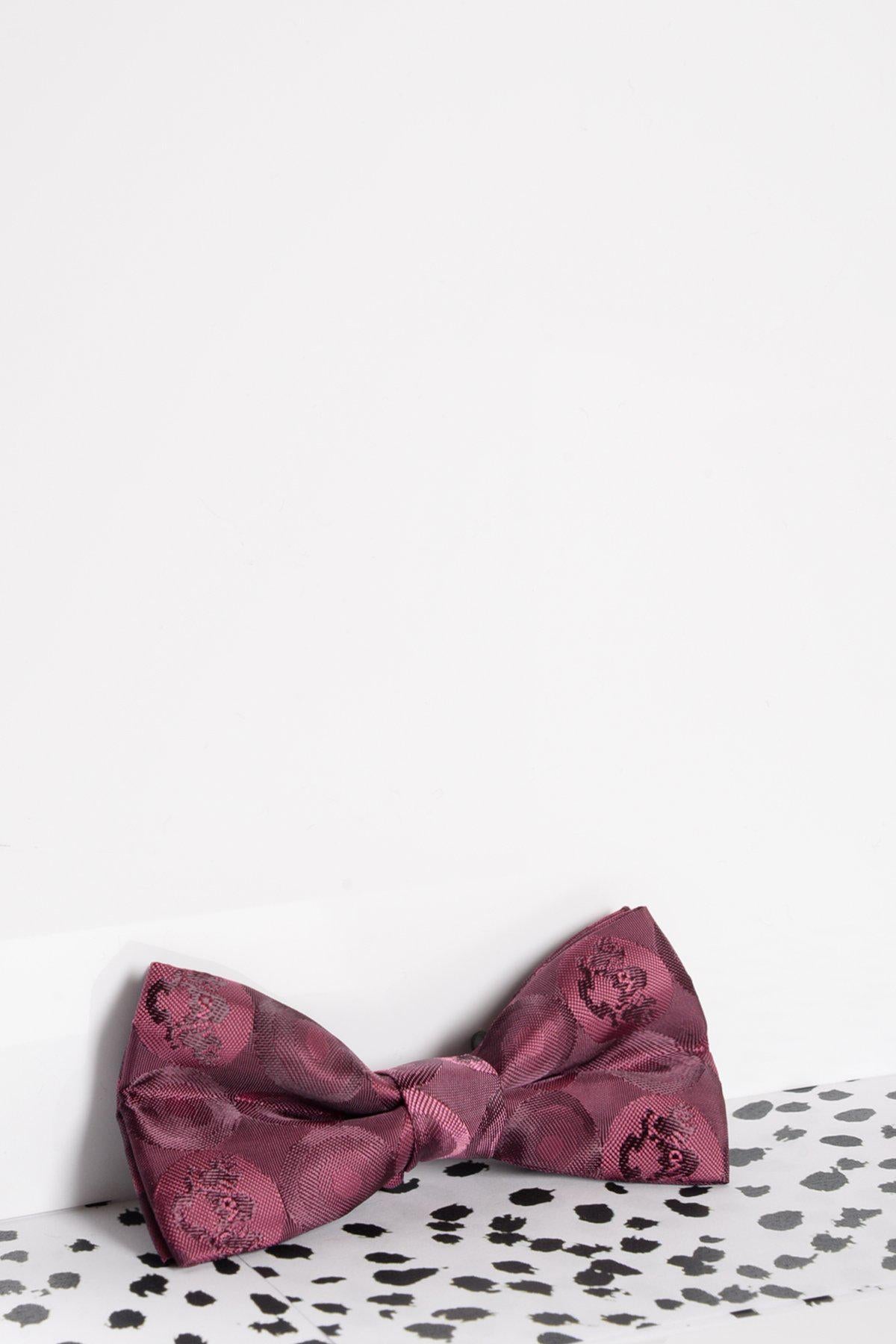 The Marc Darcy Childrens Berry Bubble Circle Print Bow Tie, featuring an adjustable neck strap, is displayed on a white surface with black speckles against a plain white background.