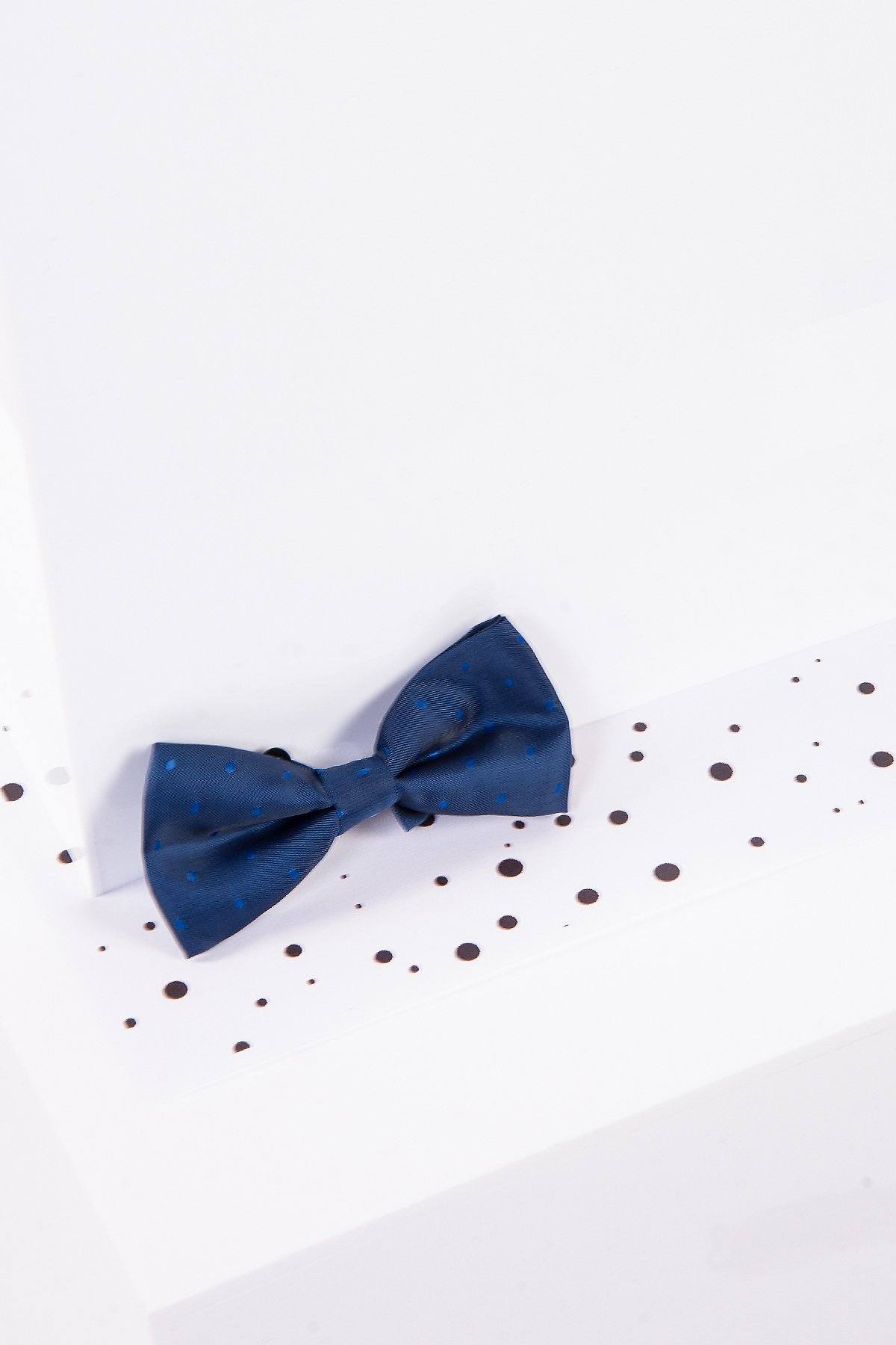 The Marc Darcy Childrens Blue Polka Dot Bow Tie features small blue dots on navy and an adjustable neck strap. Shown on a white surface with scattered black dots, it’s also available in a matching adult size.
