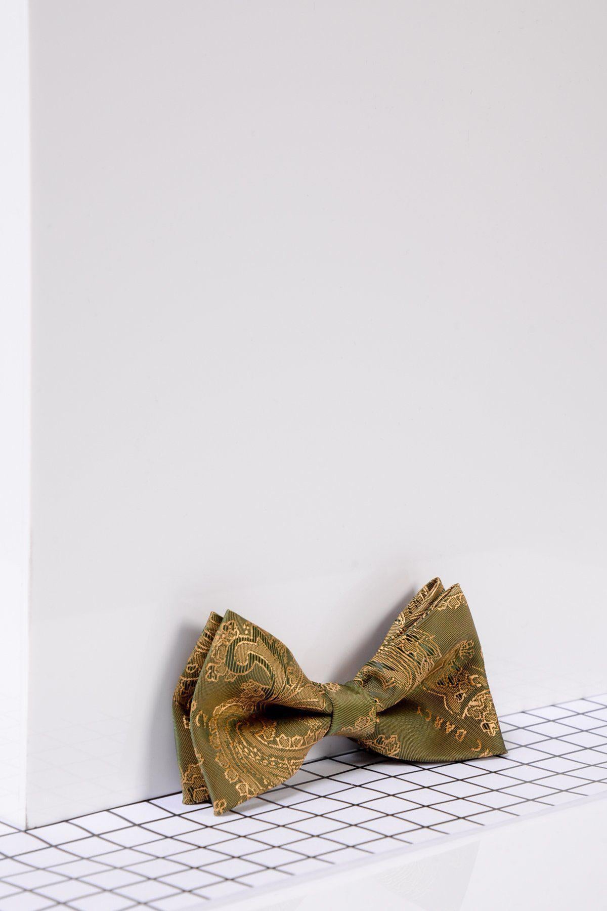 The Marc Darcy Childrens Gold Tan Paisley Print Bow Tie, ideal for formal occasions, is displayed on a white surface with a black grid pattern against a minimalist white background.