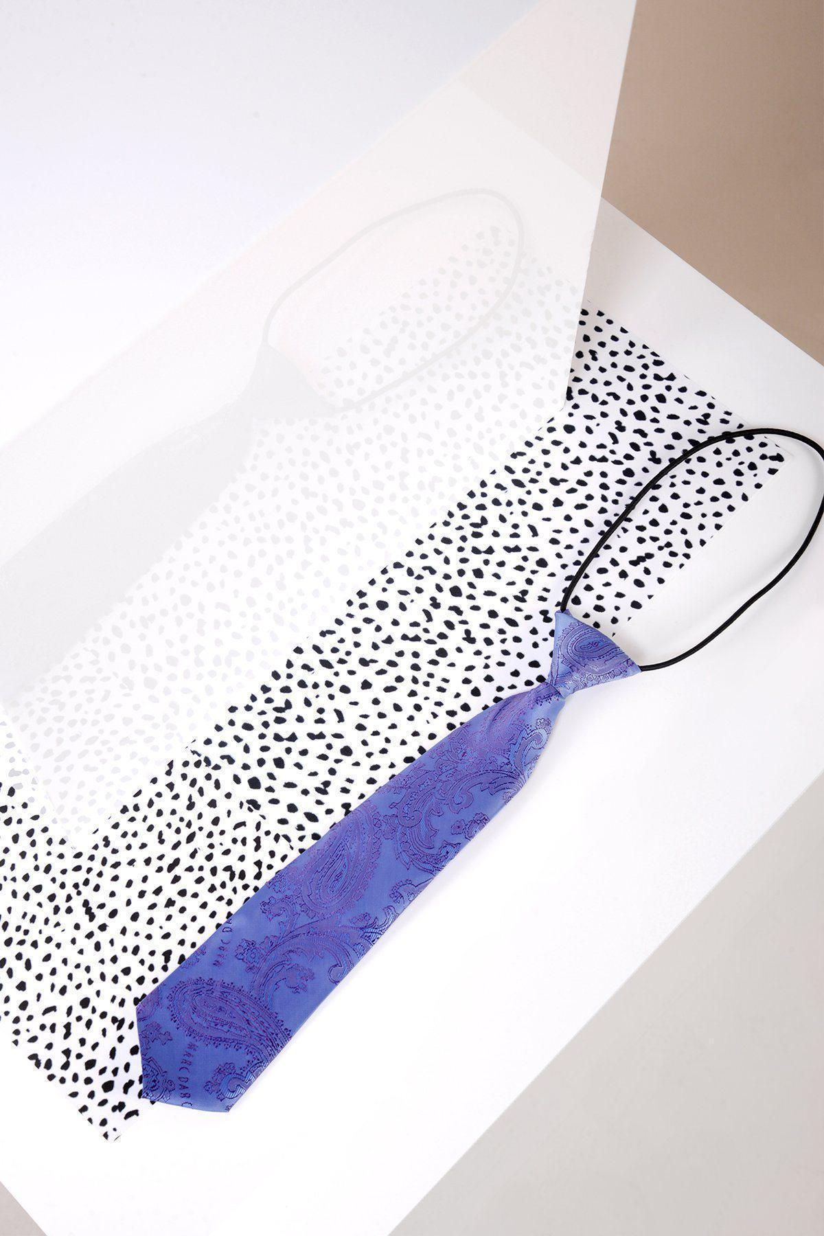 The Marc Darcy Children's Lilac Paisley Print Tie rests on a white and black spotted surface, its adjustable strap visible, with a reflective panel beneath creating a mirrored image of the tie.