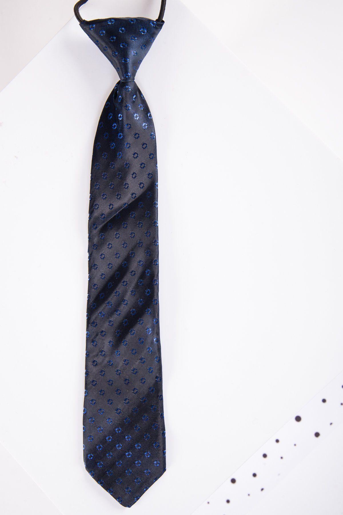 The Marc Darcy Children's Navy Spot Print Tie, featuring a subtle spot design and adjustable neck strap, hangs against a white background.