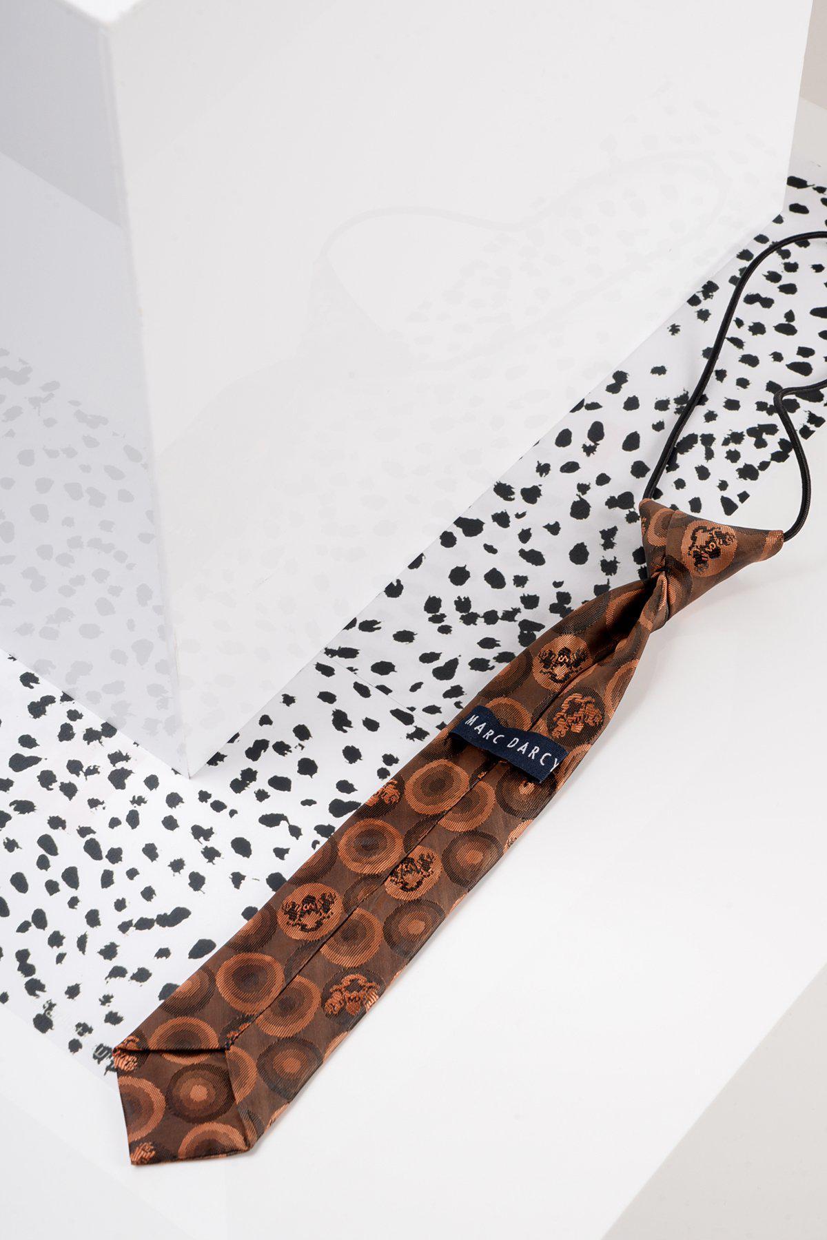 The Marc Darcy Childrens Orange Brown Bubble Circle Print Tie features a black elastic strap and label, displayed on a white surface with an abstract dotted pattern, making it a stylish match for the Jenson Marine boys suit.