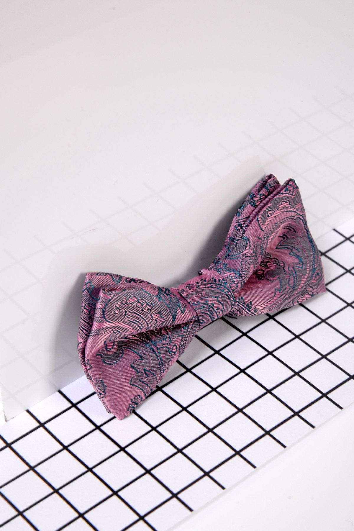 The Marc Darcy Childrens Pink Paisley Print Bow Tie rests on a white grid-patterned surface, adding a charming touch to any page boy suit or formal outfit.