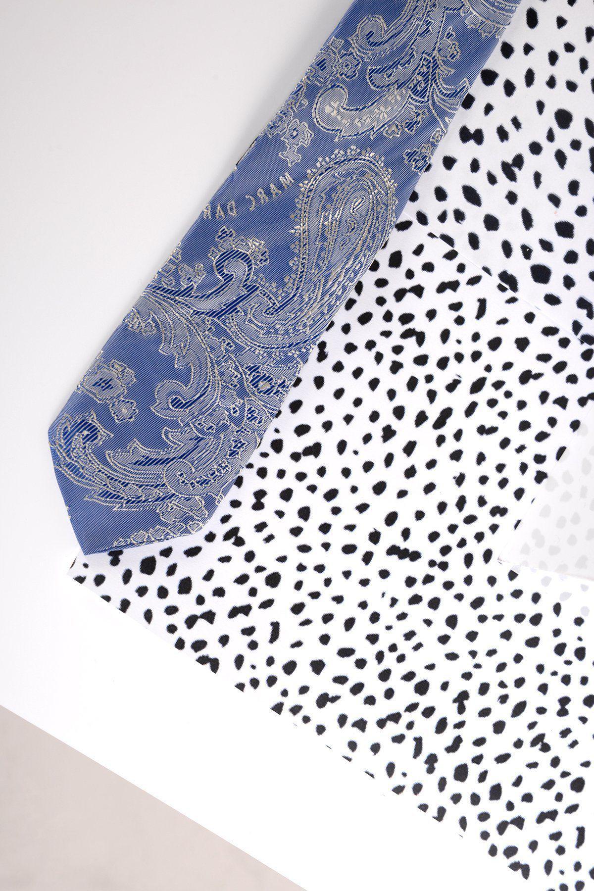 The Marc Darcy Childrens Sky Blue Paisley Print Tie is displayed diagonally on a white surface with black irregular dots, creating a bold contrast—ideal for adding flair to any formal outfit or page boy suit.