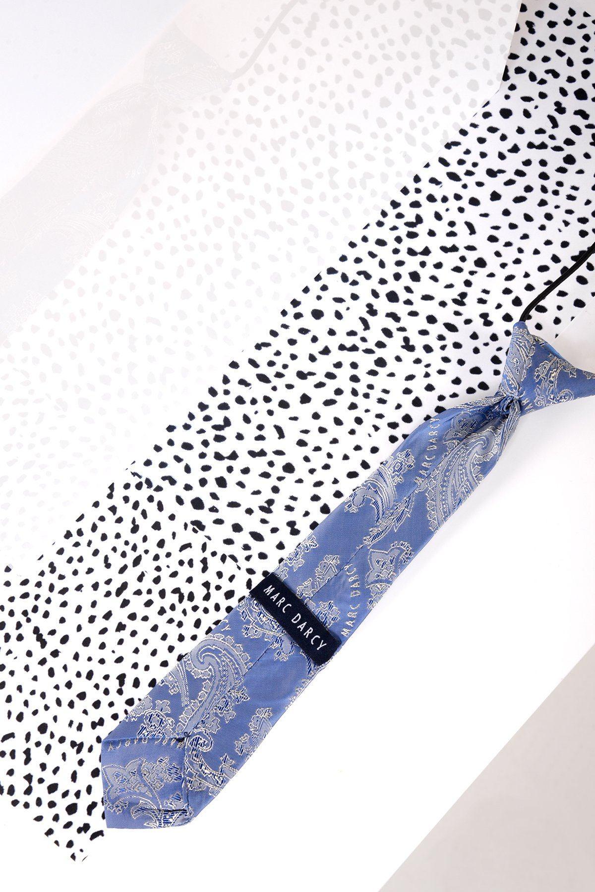 The Marc Darcy Childrens Sky Blue Paisley Print Tie is displayed on a white, black polka dot surface—a stylish addition to any page boy suit or formal outfit.