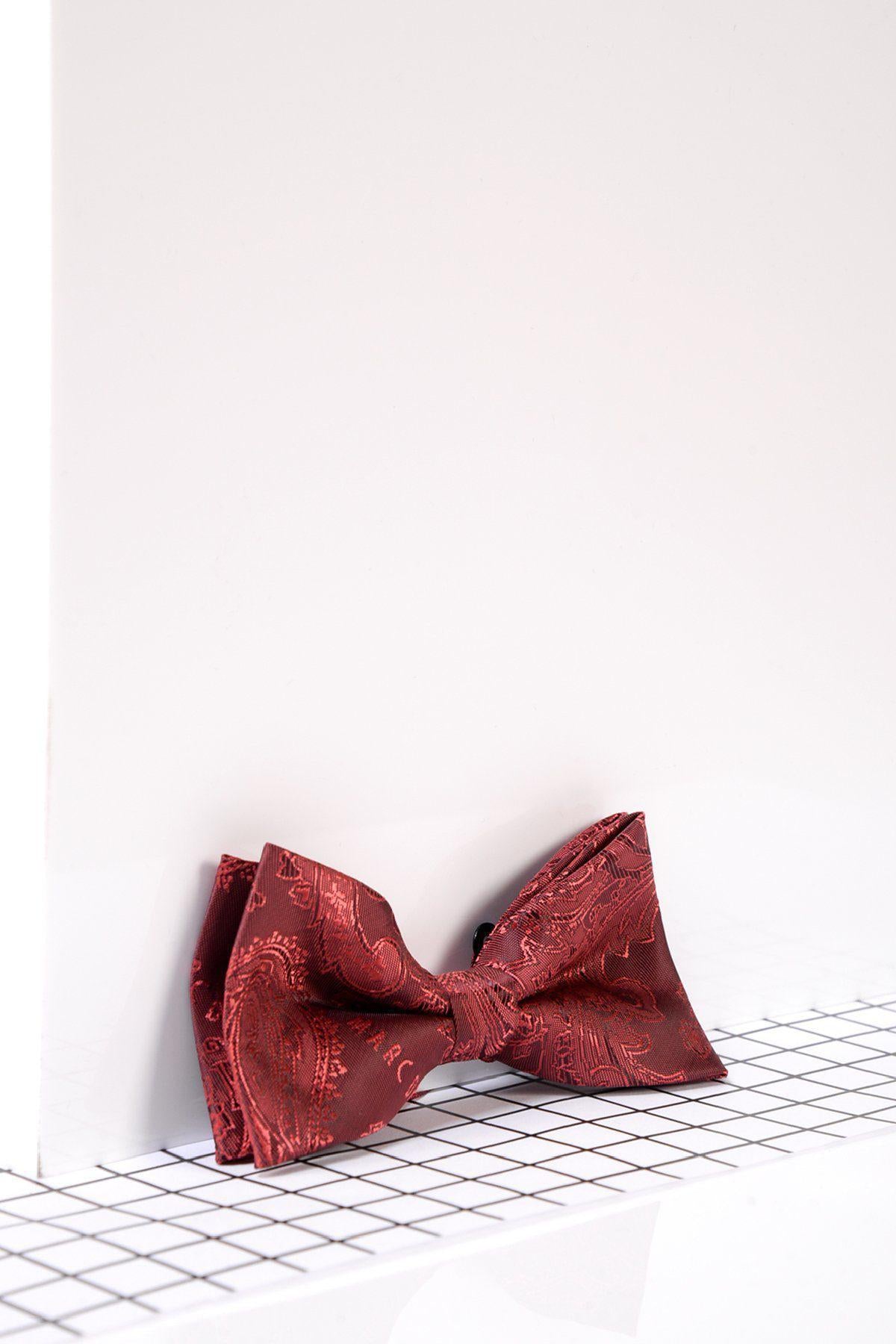 The Marc Darcy Children's Wine Paisley Print Bow Tie rests on a black and white checkered surface with a white background, making it an ideal stylish accessory for kids at any special occasion.