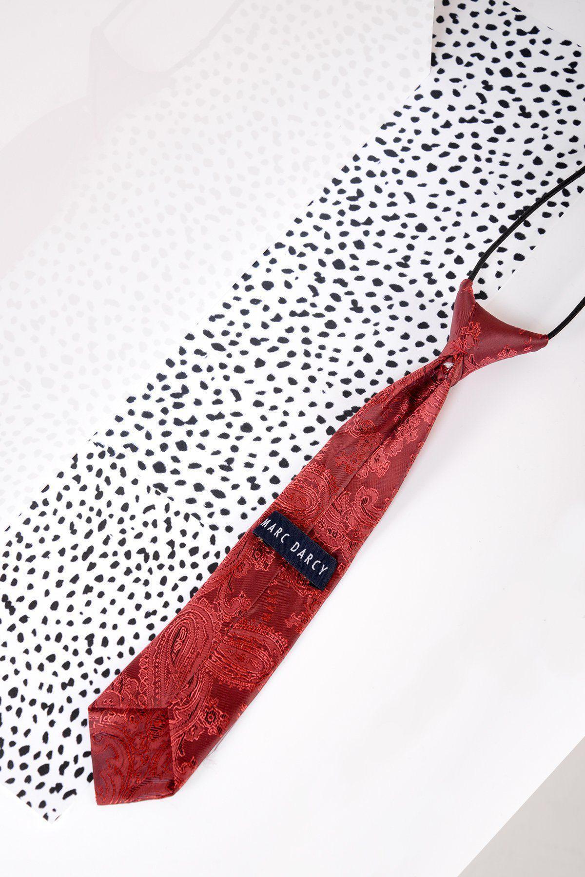 The Marc Darcy Children's Wine Paisley Print Tie rests on a white surface with a black and white dalmatian print, making it the perfect formal kids' accessory for elevating any page boy suit.