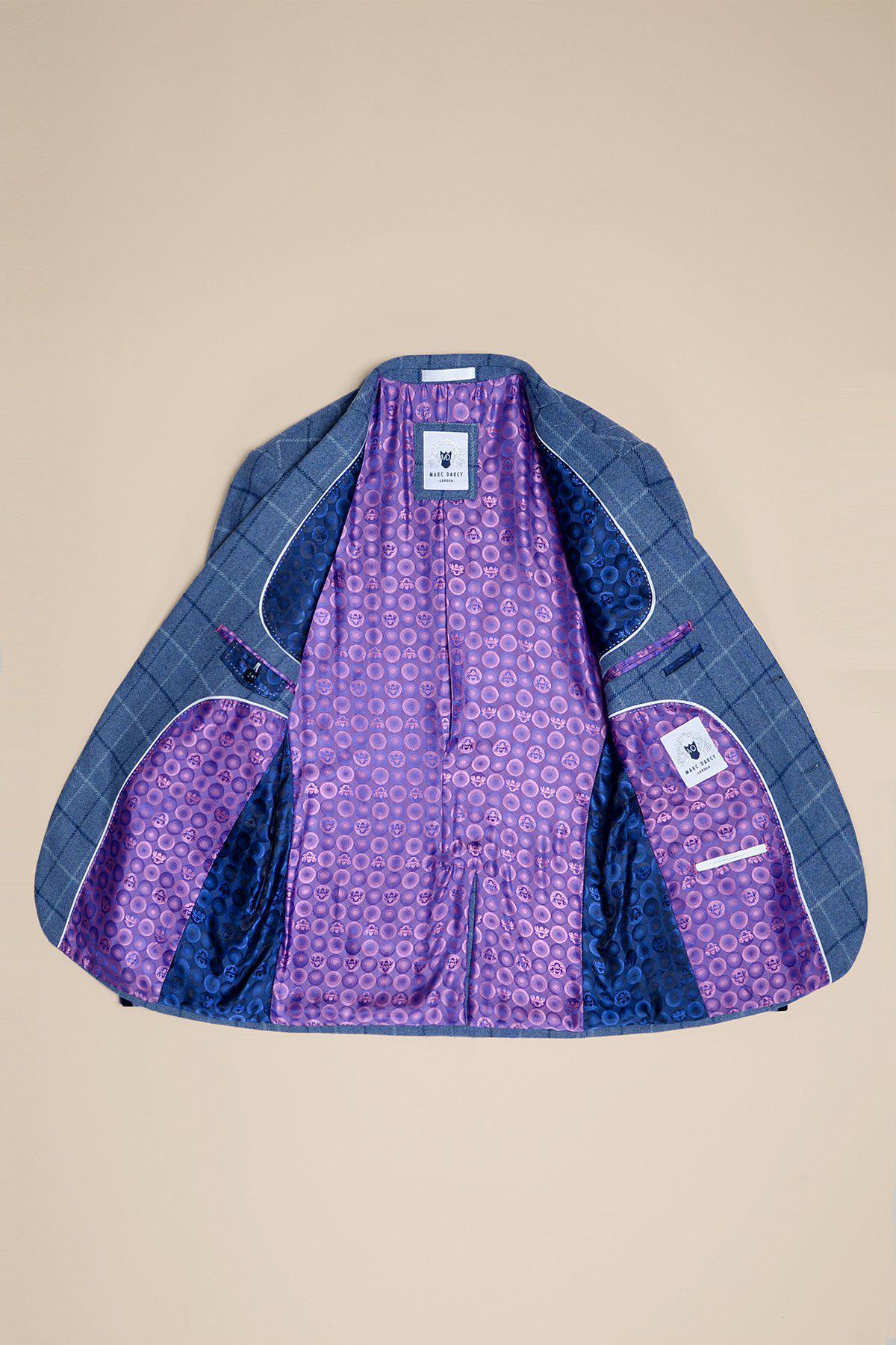 The marcdarcy CLINTON Blue Tweed Check Blazer, in a slim fit with a plaid pattern, lies open on a beige surface, showing its vibrant purple and blue patterned lining and labeled inner pockets.