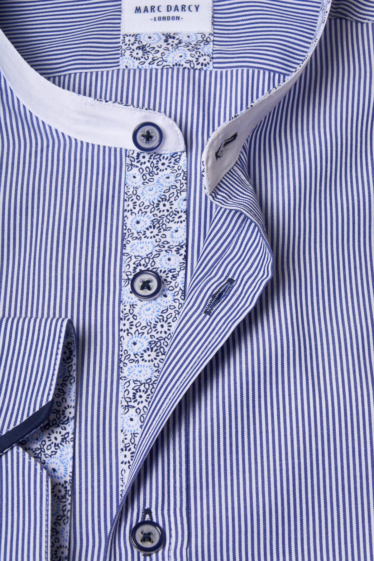 Close-up of the Marc Darcy COOPER Grandad Collar Navy Stripe Shirt, showcasing blue and white stripes, a white inner collar, floral button placket, and matching blue buttons. The shirt is partially unbuttoned to reveal these details.
