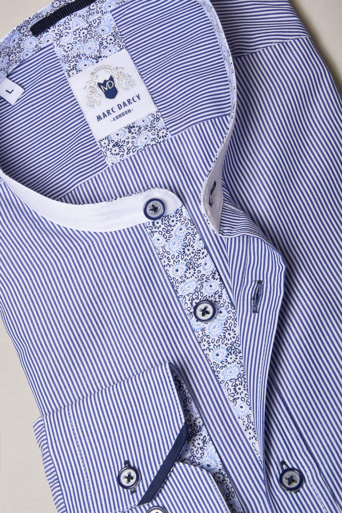 A close-up of the Marc Darcy COOPER Grandad Collar Navy Stripe Shirt, showcasing blue and white pinstripes, a crisp white collar, and a contrasting patterned placket and collar lining.